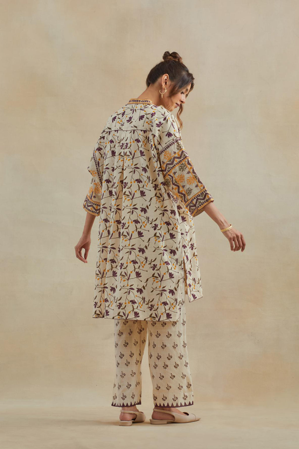Beige cotton easy fit short kurta with all-over yellow & purple hand block print, highlighted with silk thread embroidery, paired with beige cotton straight pants with all-over small booti hand block print.
