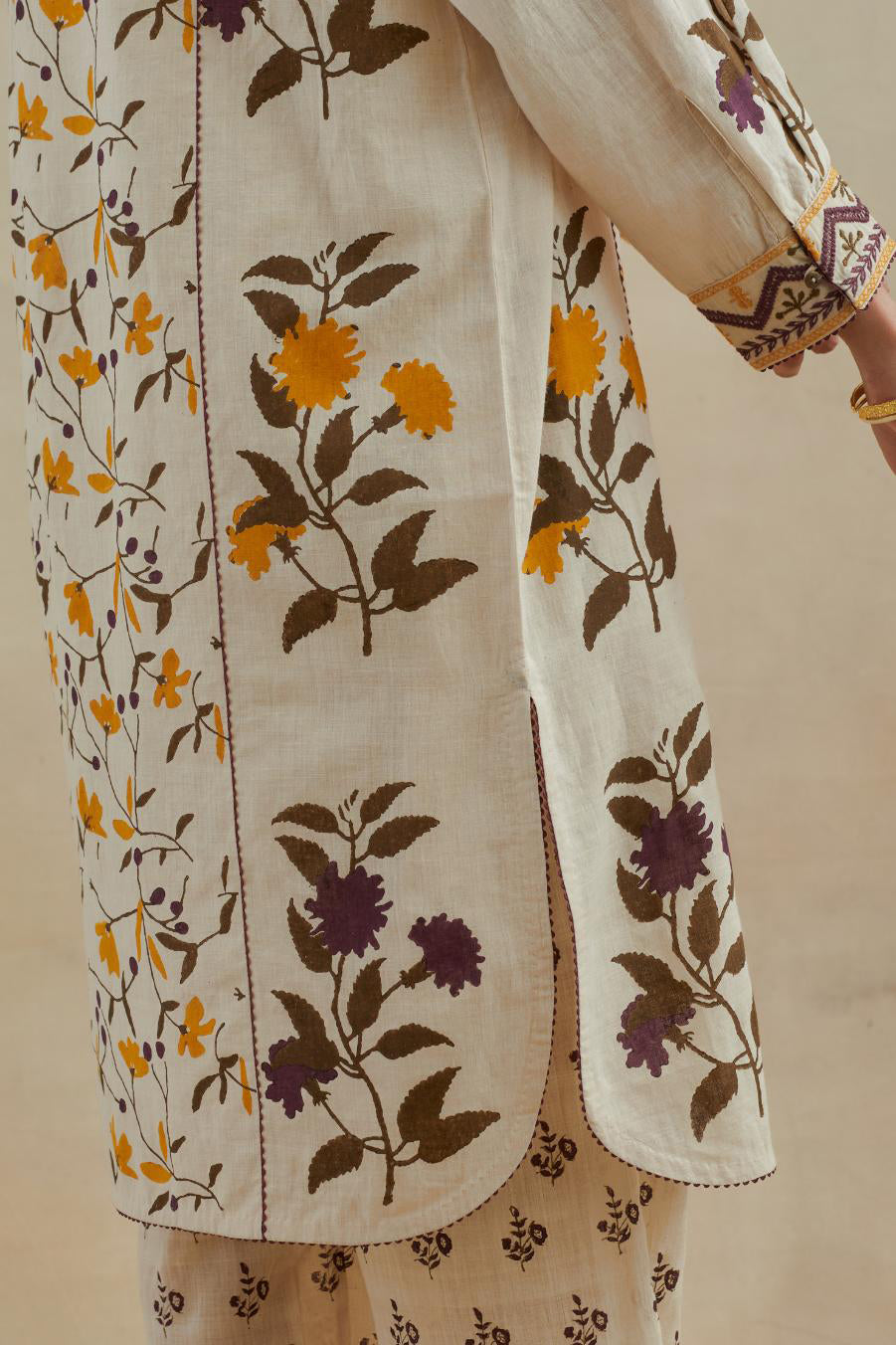 Beige short kurta crafted from soft cotton, featuring an all-over hand block print of yellow and purple flowers, paired with Beige cotton straight pants with all-over small booti hand block print.