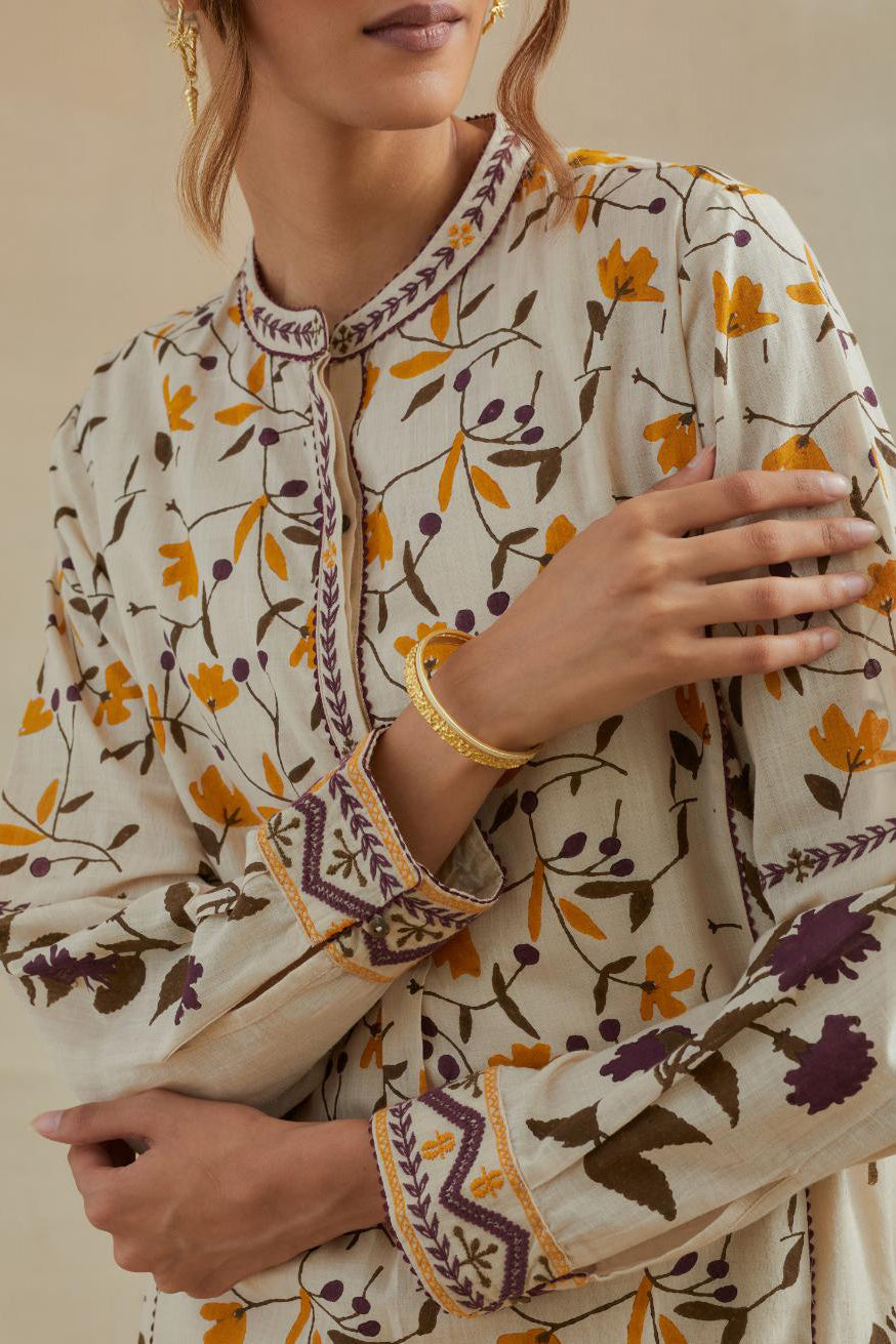Beige short kurta crafted from soft cotton, featuring an all-over hand block print of yellow and purple flowers, paired with Beige cotton straight pants with all-over small booti hand block print.