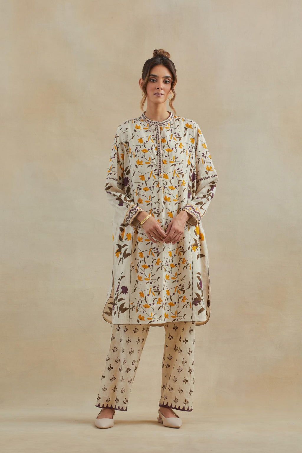 Beige short kurta crafted from soft cotton, featuring an all-over hand block print of yellow and purple flowers, paired with Beige cotton straight pants with all-over small booti hand block print.