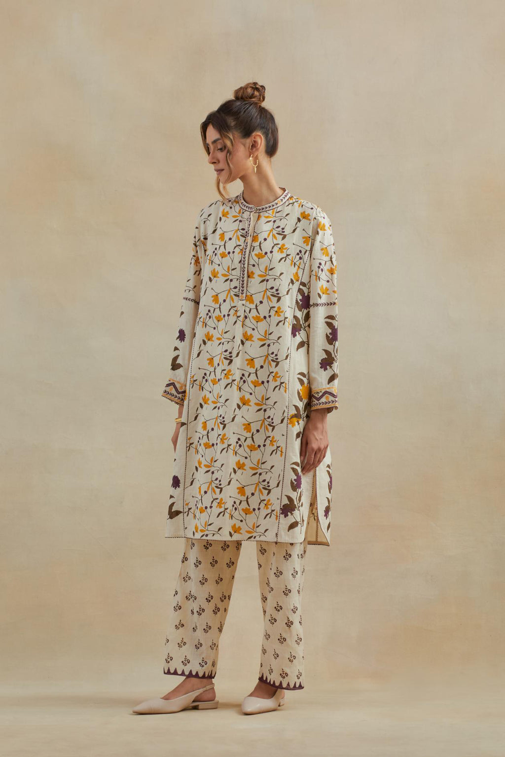 Beige short kurta crafted from soft cotton, featuring an all-over hand block print of yellow and purple flowers, paired with Beige cotton straight pants with all-over small booti hand block print.
