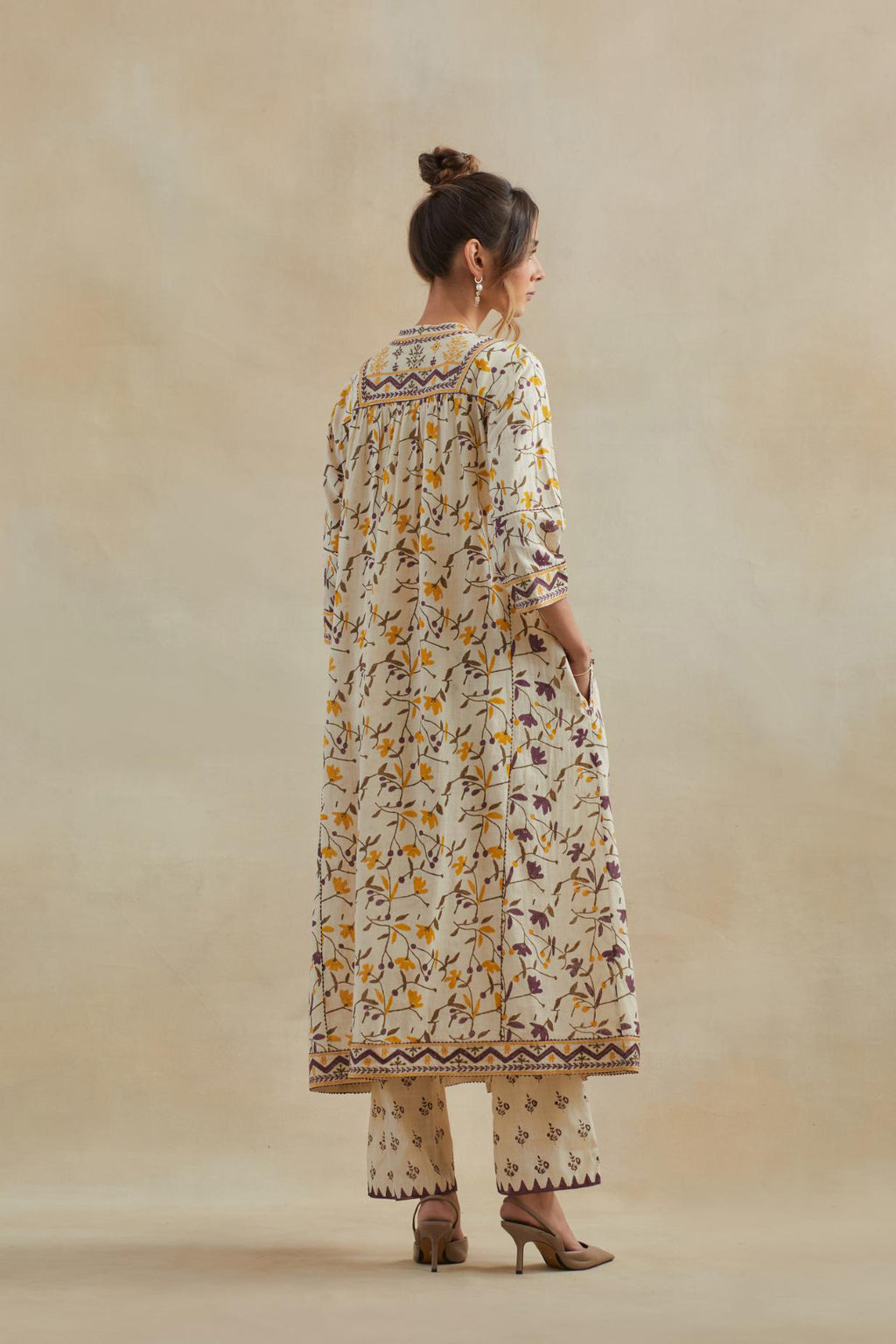 A beige cotton kurta dress set featuring an all-over yellow and purple flower hand block print.