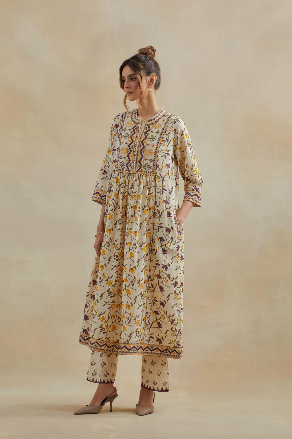 A beige cotton kurta dress set featuring an all-over yellow and purple flower hand block print.