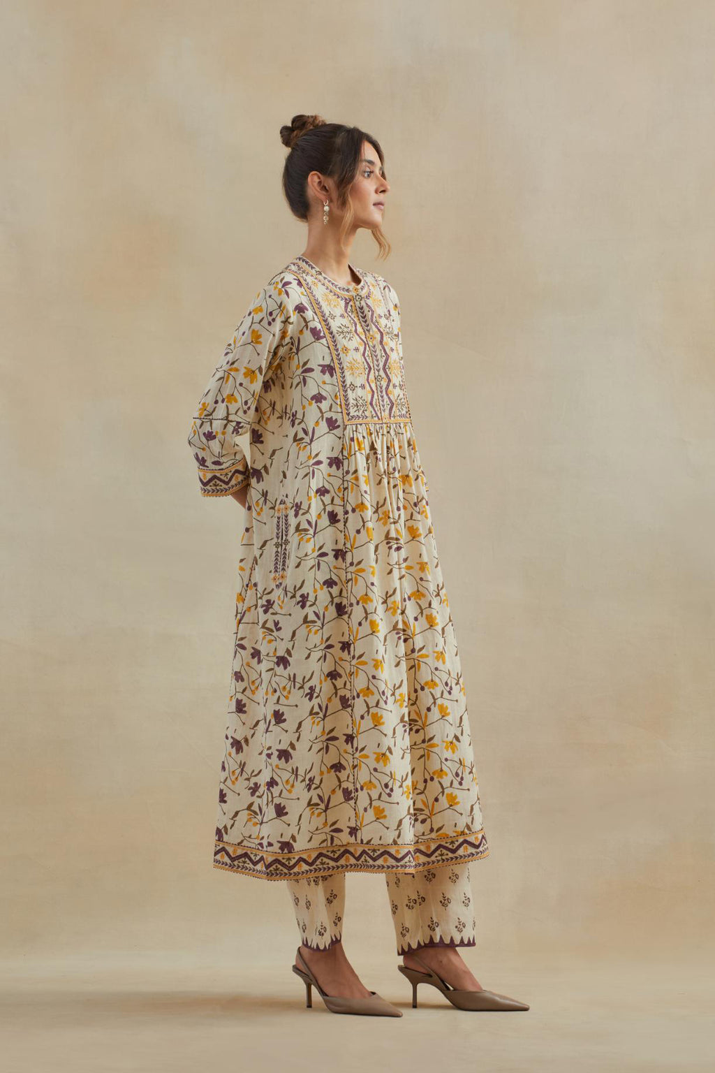 A beige cotton kurta dress set featuring an all-over yellow and purple flower hand block print.