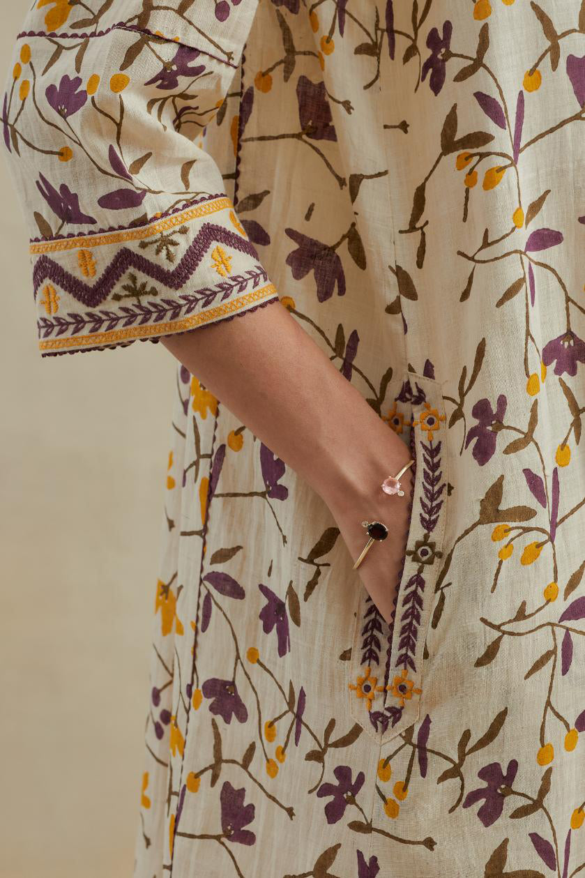 A beige cotton kurta dress set featuring an all-over yellow and purple flower hand block print.