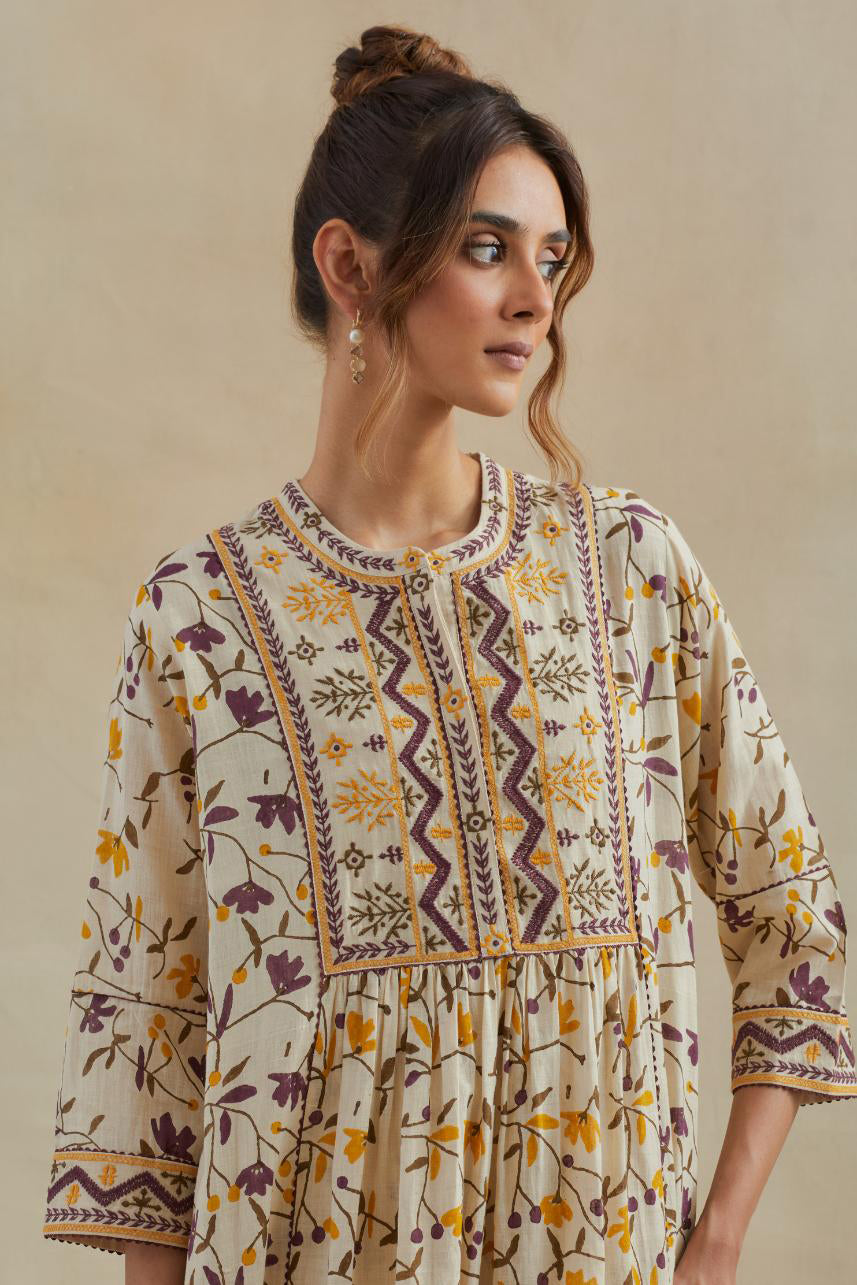 A beige cotton kurta dress set featuring an all-over yellow and purple flower hand block print.