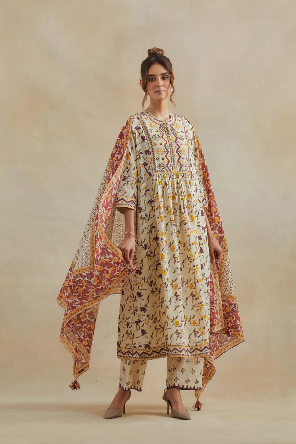 A beige cotton kurta dress set featuring an all-over yellow and purple flower hand block print.