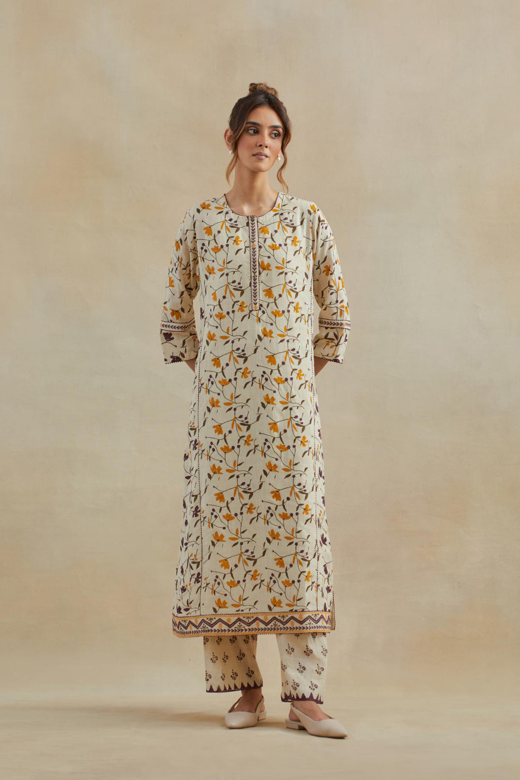 Beige cotton straight kurta set with all-over yellow & purple colored flower hand block print & and side panels.