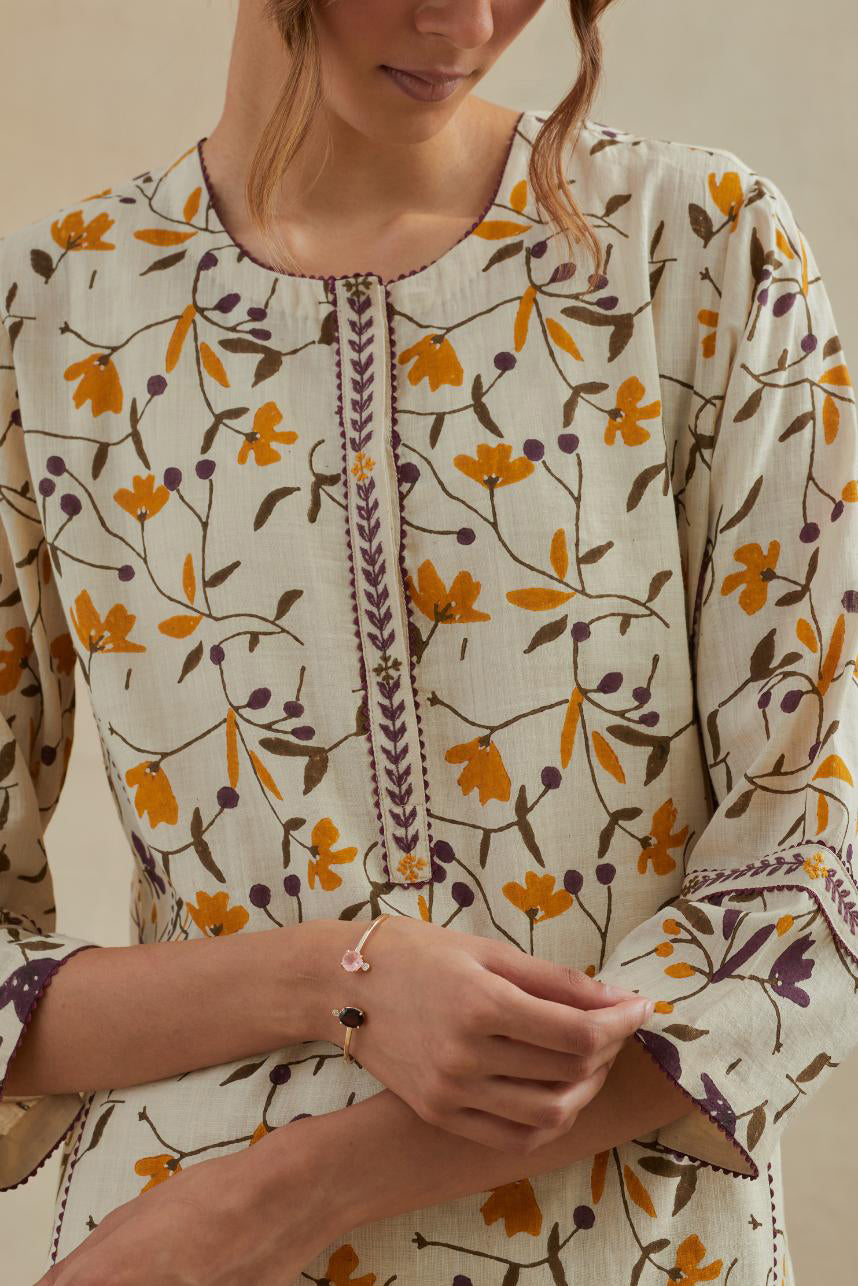 Beige cotton straight kurta set with all-over yellow & purple colored flower hand block print & and side panels.