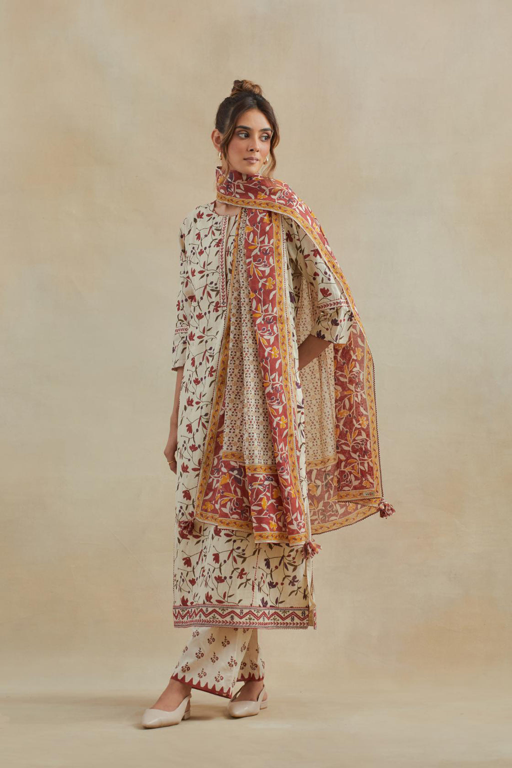 Beige cotton straight kurta set with all-over rust & green colored flower hand block print & and side panels.