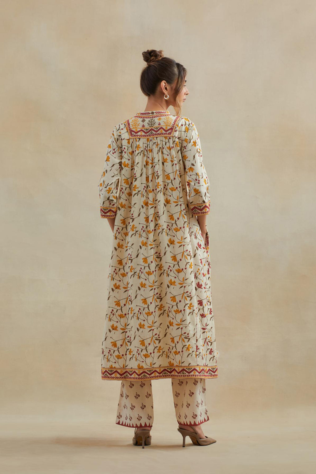 A beige cotton kurta dress set featuring an all-over yellow and red flower hand block print.