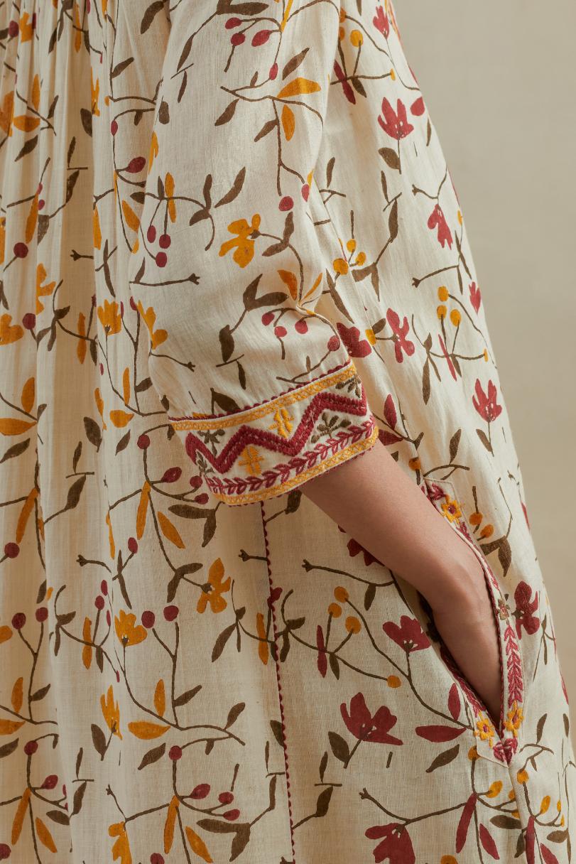 A beige cotton kurta dress set featuring an all-over yellow and red flower hand block print.