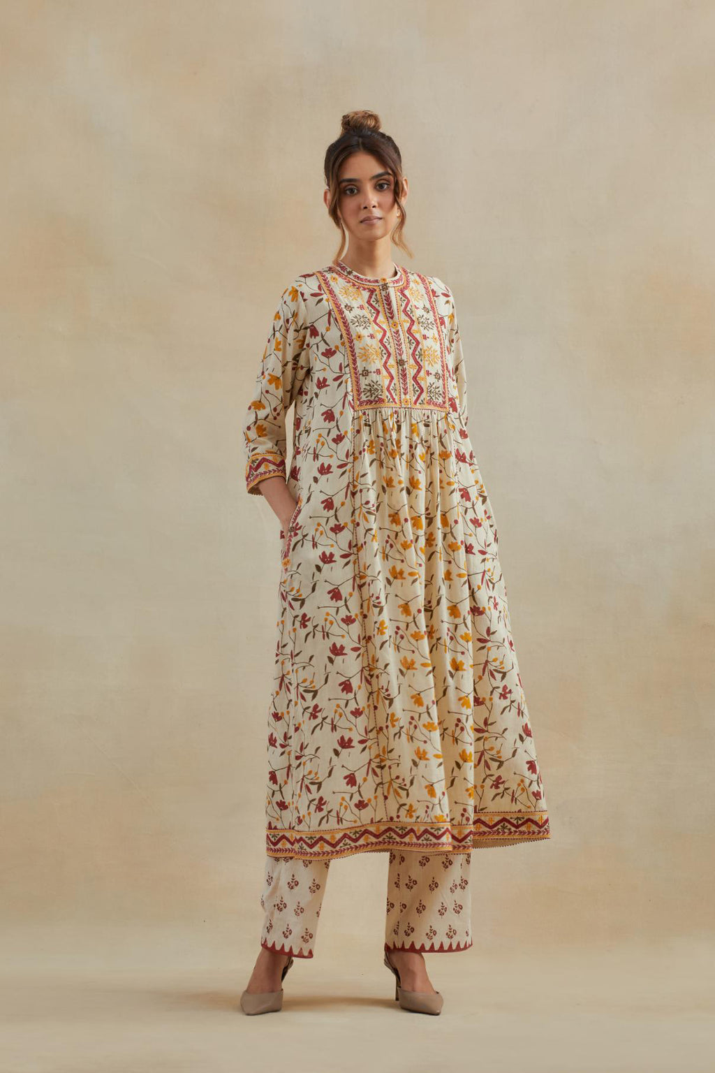 A beige cotton kurta dress set featuring an all-over yellow and red flower hand block print.
