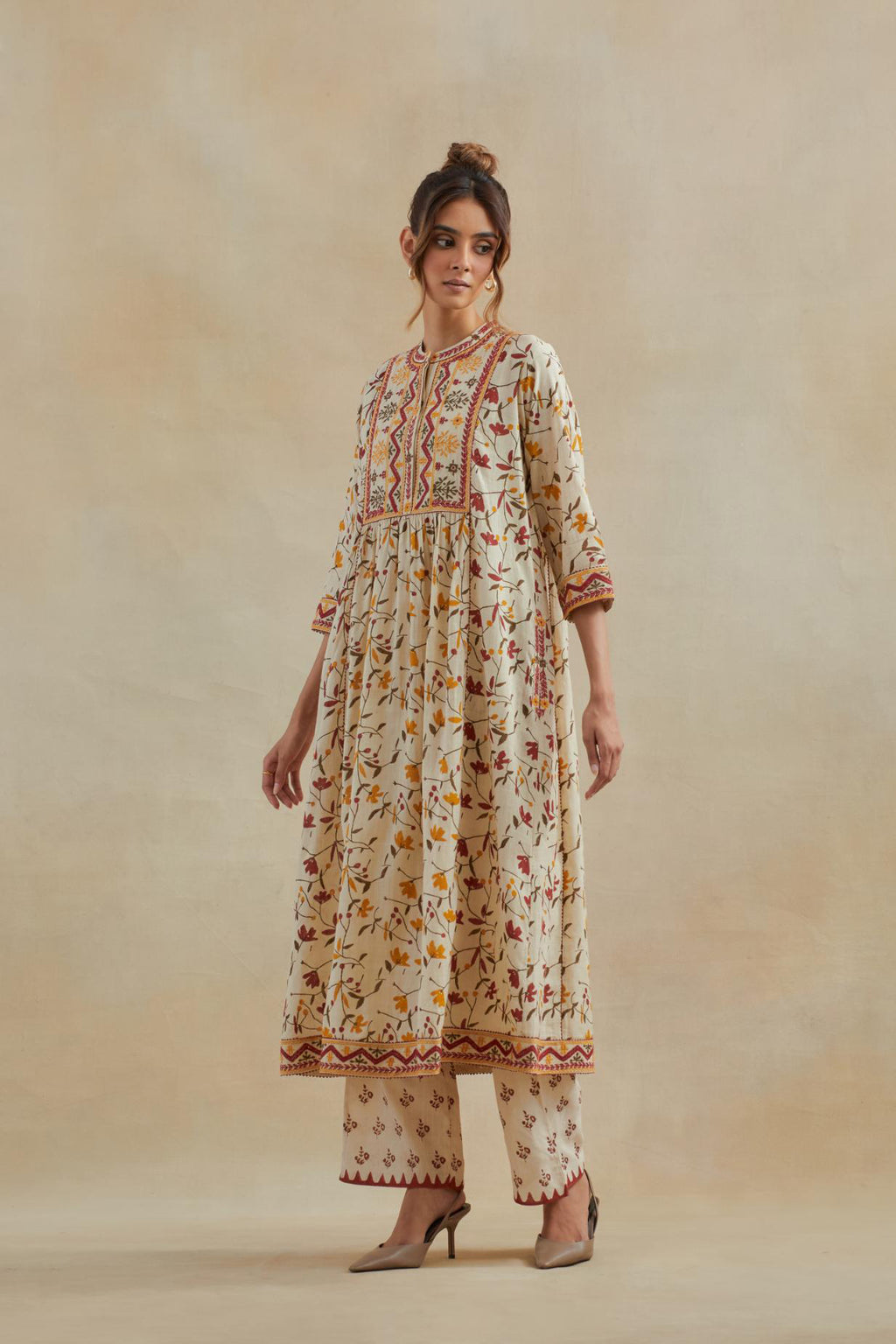 A beige cotton kurta dress set featuring an all-over yellow and red flower hand block print.