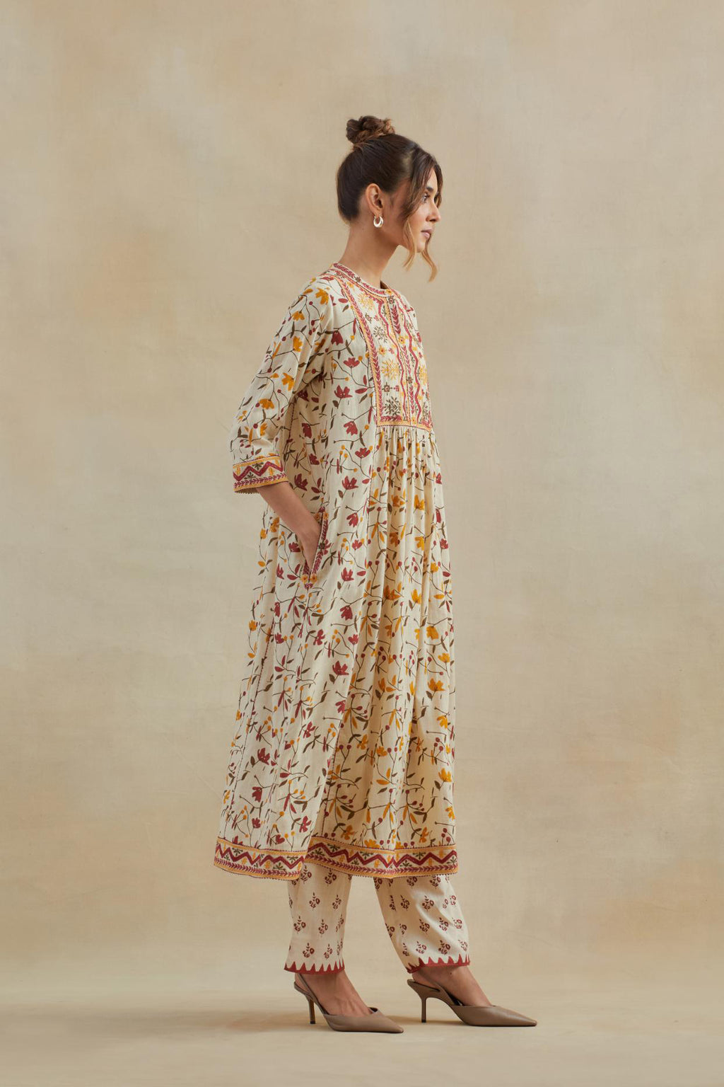 A beige cotton kurta dress set featuring an all-over yellow and red flower hand block print.