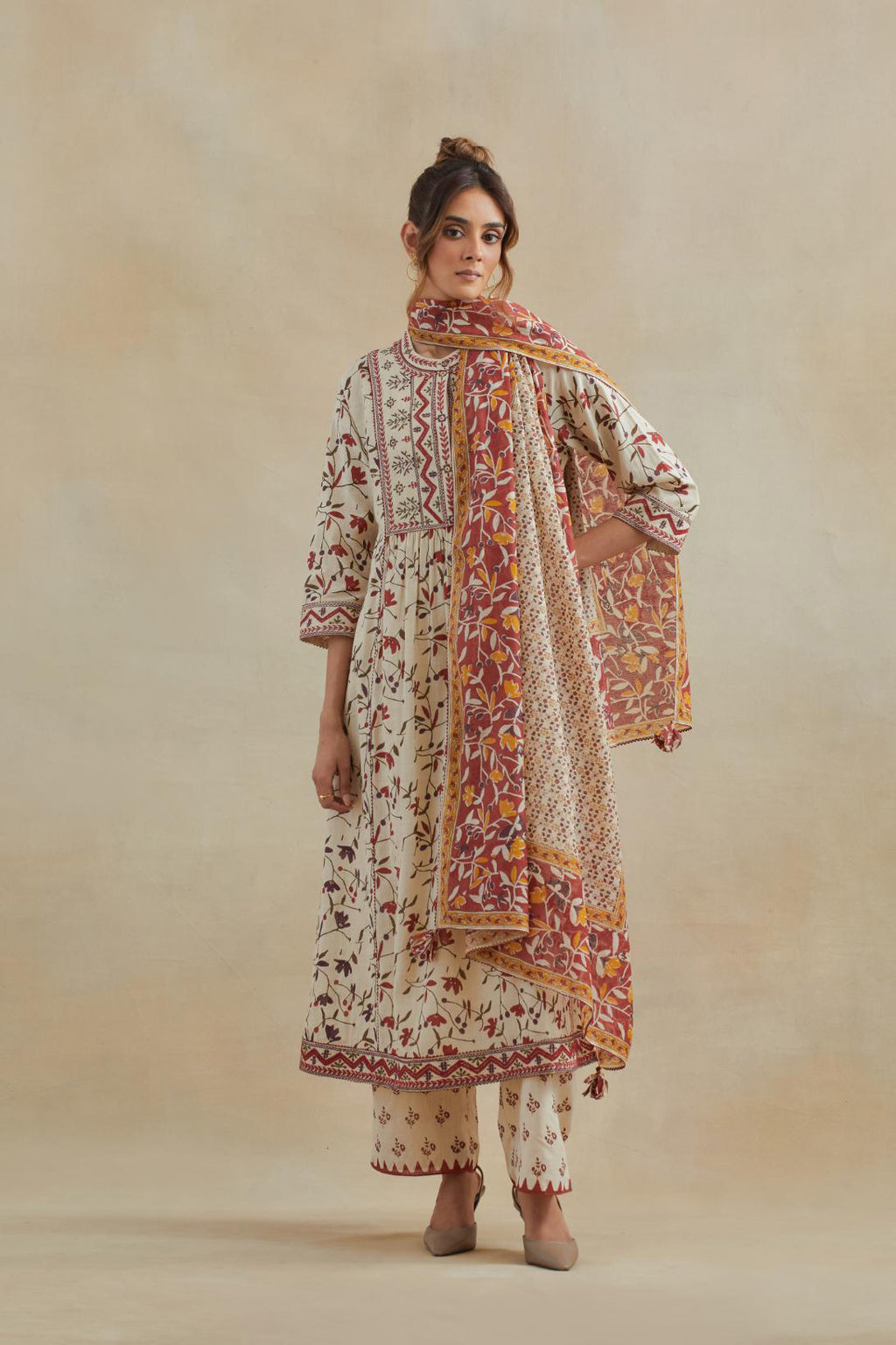 A beige cotton kurta dress set featuring an all-over rust & green flower hand block print.