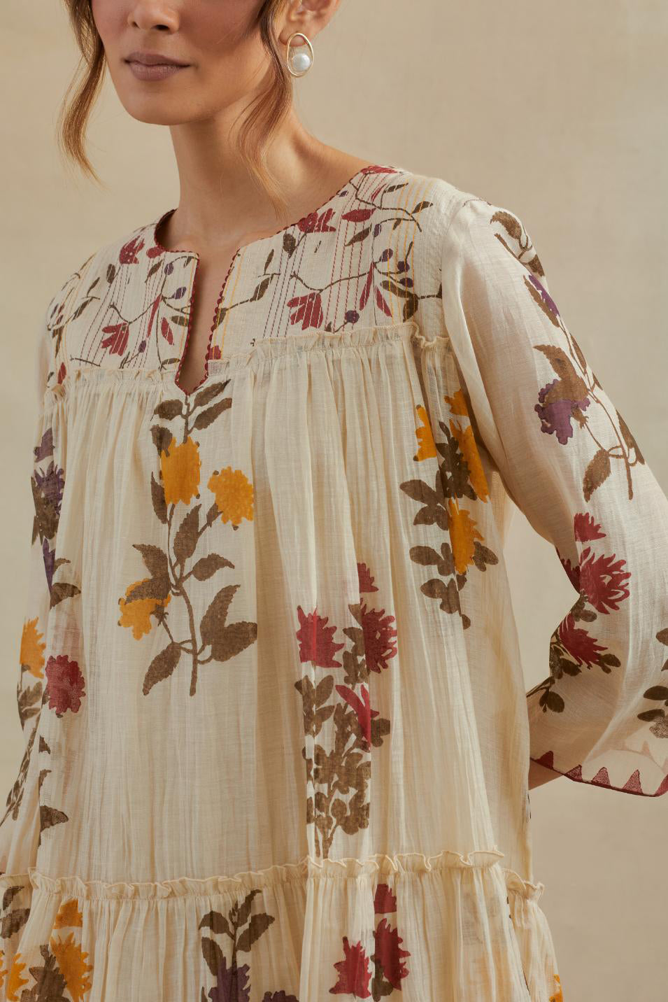 Beige cotton chanderi three-tiered kurta set with quilted yoke and all-over multi colored floral hand block print.
