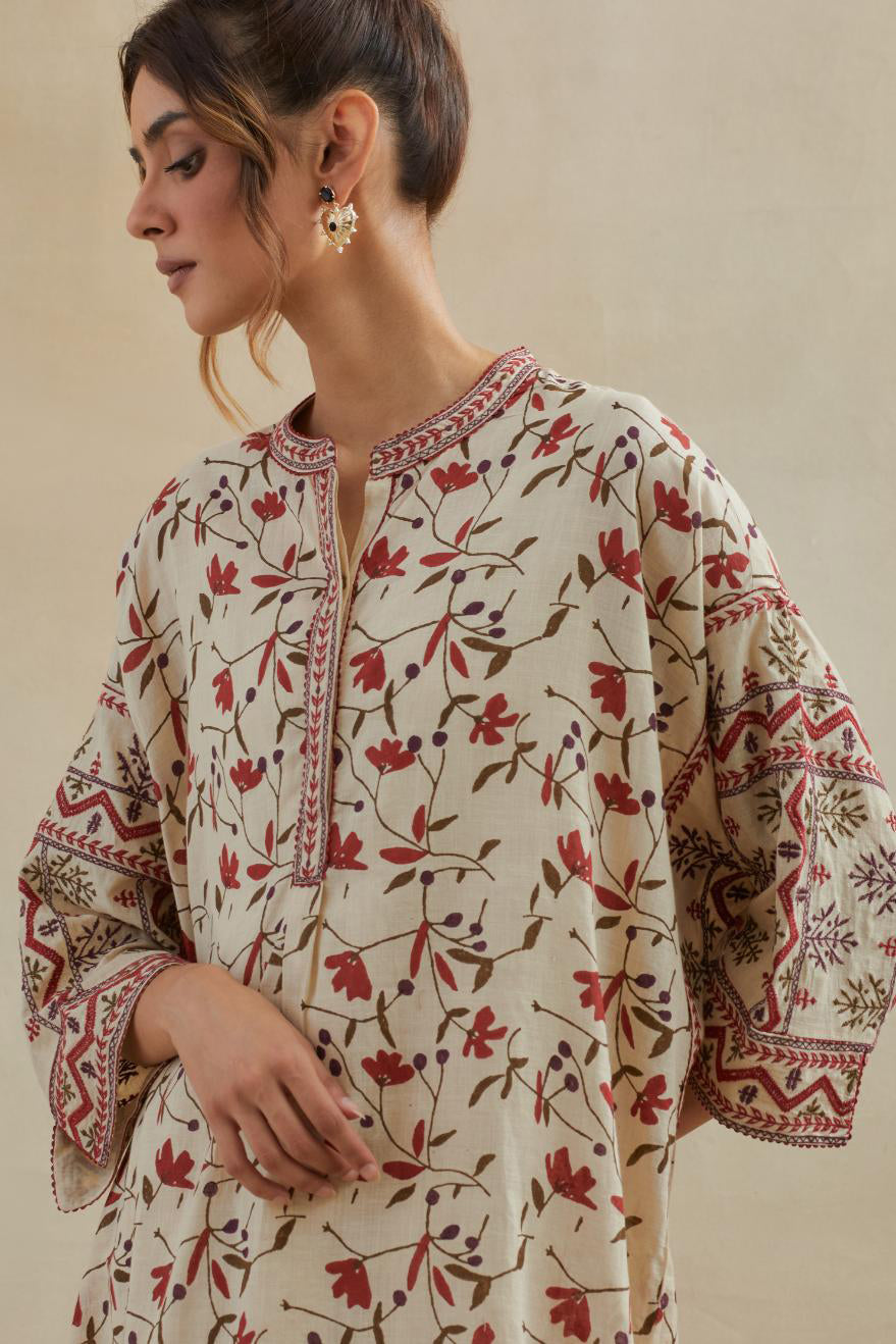 Beige cotton easy fit short kurta with all-over rust & green hand block print, highlighted with silk thread embroidery, paired with beige cotton straight pants with all-over small booti hand block print.
