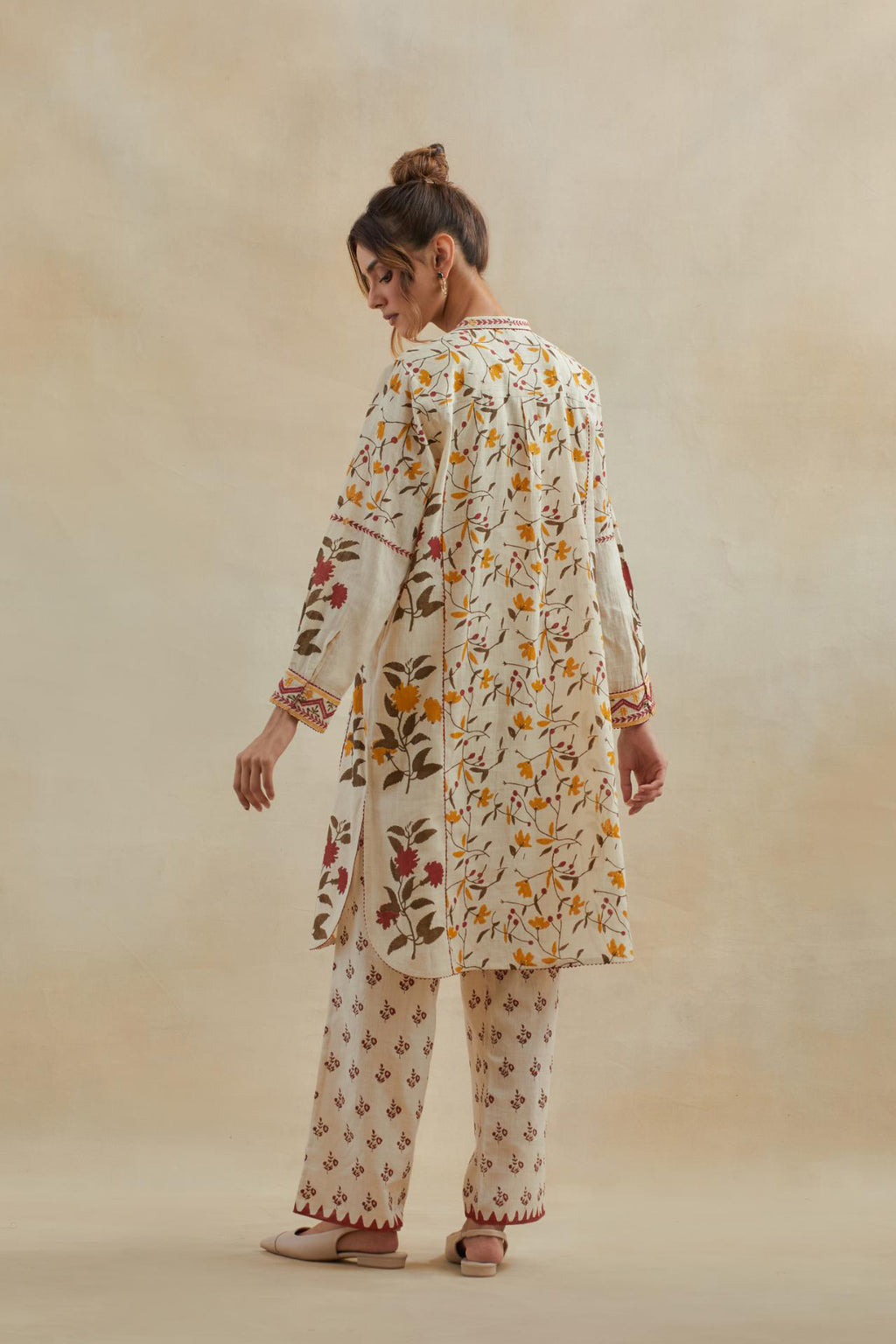Beige short kurta crafted from soft cotton, featuring an all-over hand block print of yellow and red flowers, paired with Beige cotton straight pants with all-over small booti hand block print.