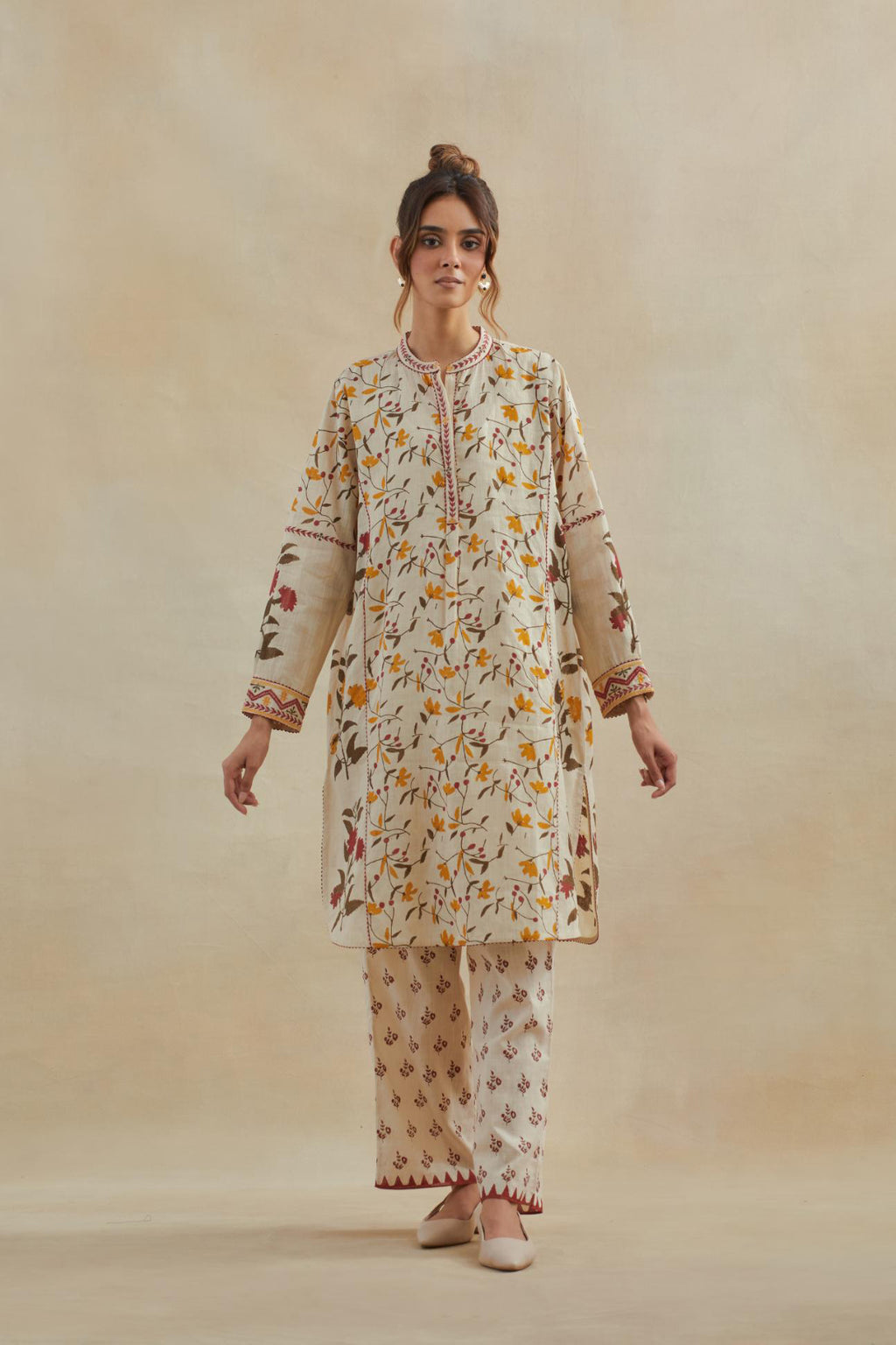 Beige short kurta crafted from soft cotton, featuring an all-over hand block print of yellow and red flowers, paired with Beige cotton straight pants with all-over small booti hand block print.
