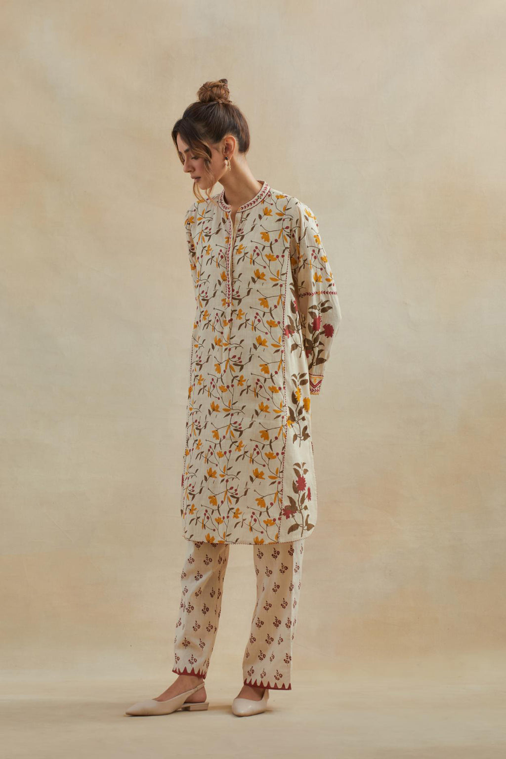 Beige short kurta crafted from soft cotton, featuring an all-over hand block print of yellow and red flowers, paired with Beige cotton straight pants with all-over small booti hand block print.