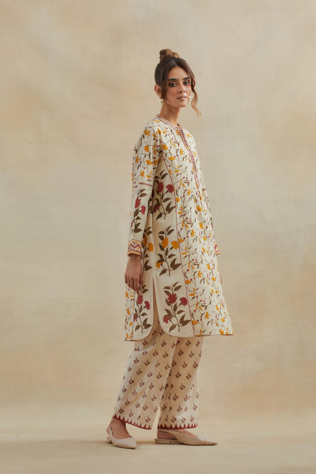 Beige short kurta crafted from soft cotton, featuring an all-over hand block print of yellow and red flowers, paired with Beige cotton straight pants with all-over small booti hand block print.