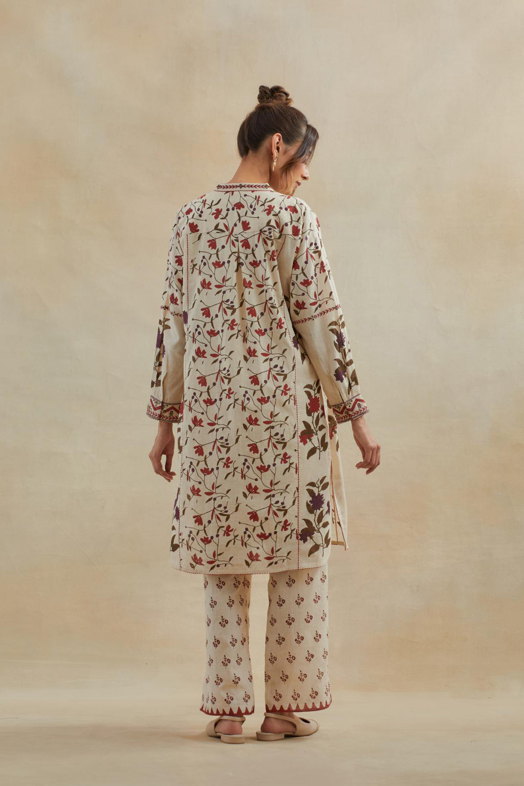 Beige short kurta crafted from soft cotton, featuring an all-over hand block print of red & green flowers, paired with Beige cotton straight pants with all-over small booti hand block print.
