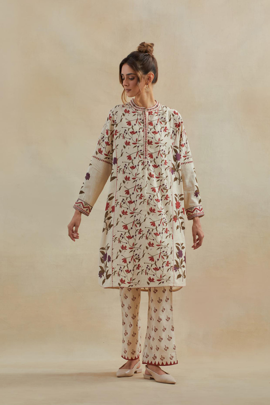 Beige short kurta crafted from soft cotton, featuring an all-over hand block print of red & green flowers, paired with Beige cotton straight pants with all-over small booti hand block print.