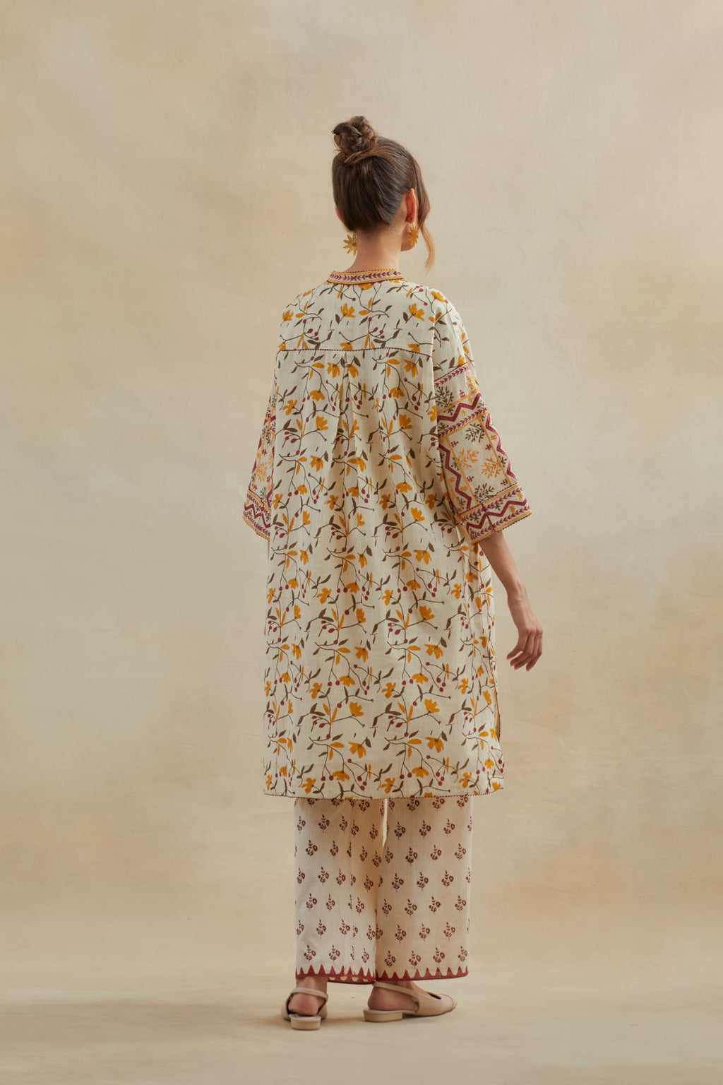 Beige cotton easy fit short kurta with all-over yellow & rust hand block print, highlighted with silk thread embroidery, paired with beige cotton straight pants with all-over small booti hand block print.