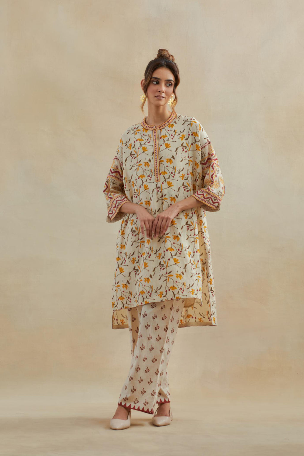 Beige cotton easy fit short kurta with all-over yellow & rust hand block print, highlighted with silk thread embroidery, paired with beige cotton straight pants with all-over small booti hand block print.