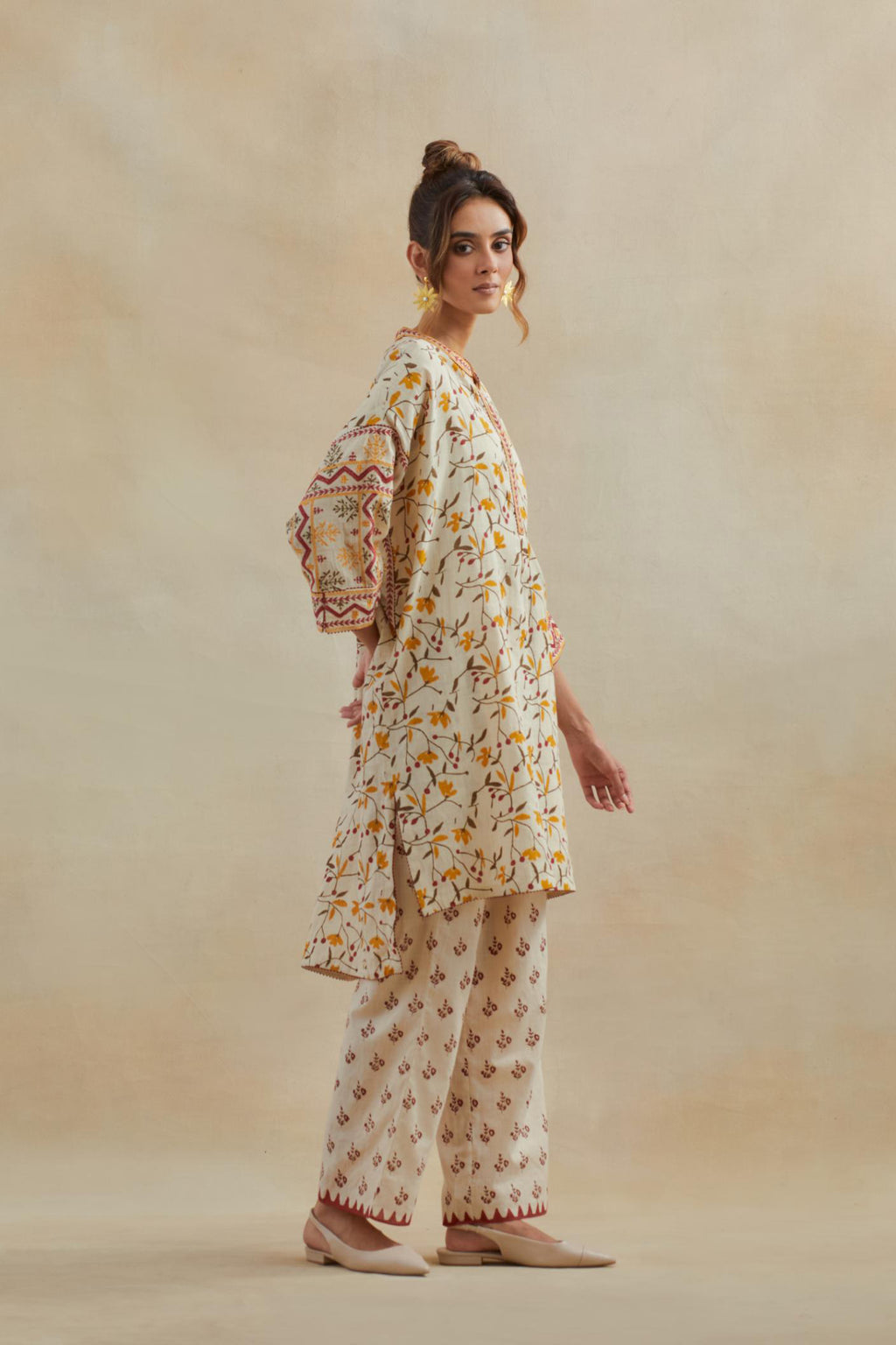 Beige cotton easy fit short kurta with all-over yellow & rust hand block print, highlighted with silk thread embroidery, paired with beige cotton straight pants with all-over small booti hand block print.