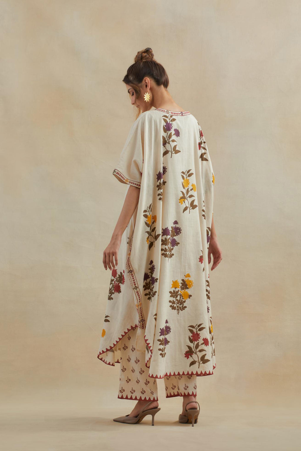 Beige cotton easy fit kaftan with all-over multi colored flower hand block print, highlighted with thread embroidery at sides, paired with beige cotton straight pants with all-over small booti hand block print.