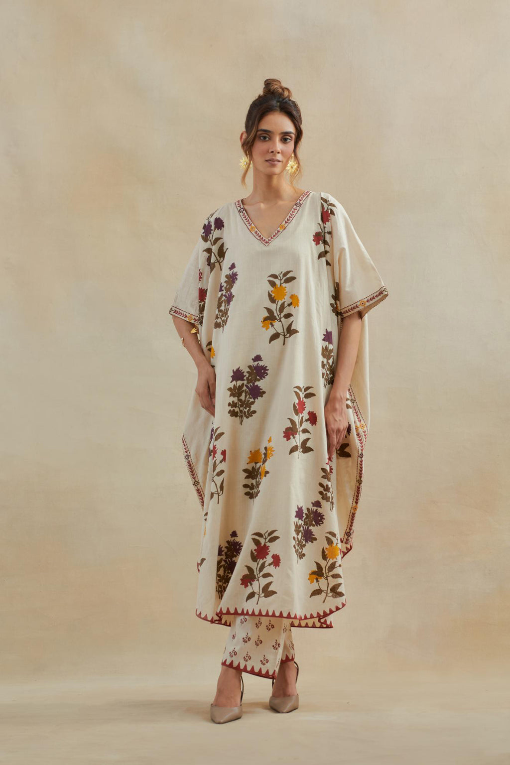 Beige cotton easy fit kaftan with all-over multi colored flower hand block print, highlighted with thread embroidery at sides, paired with beige cotton straight pants with all-over small booti hand block print.