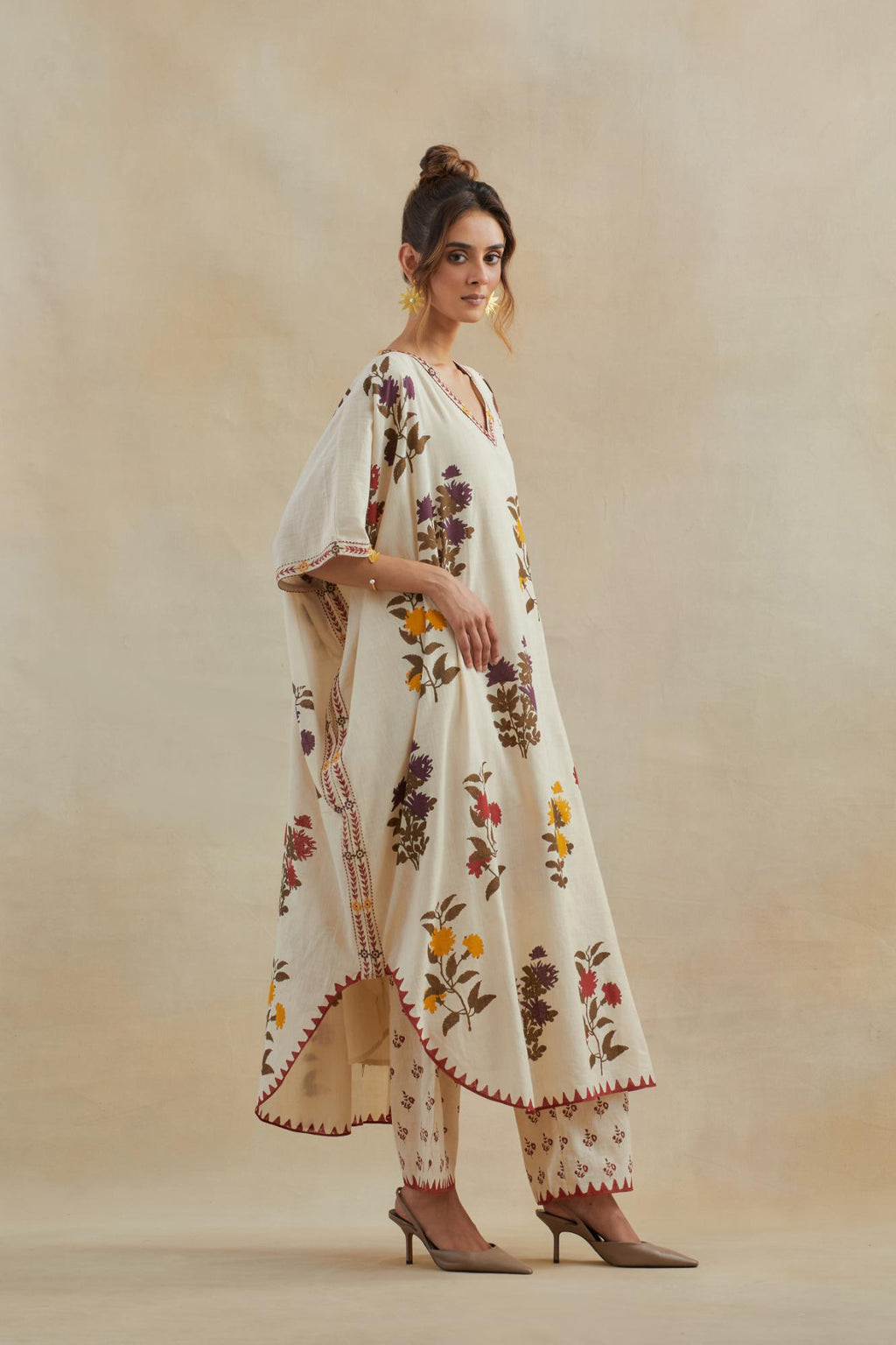 Beige cotton easy fit kaftan with all-over multi colored flower hand block print, highlighted with thread embroidery at sides, paired with beige cotton straight pants with all-over small booti hand block print.