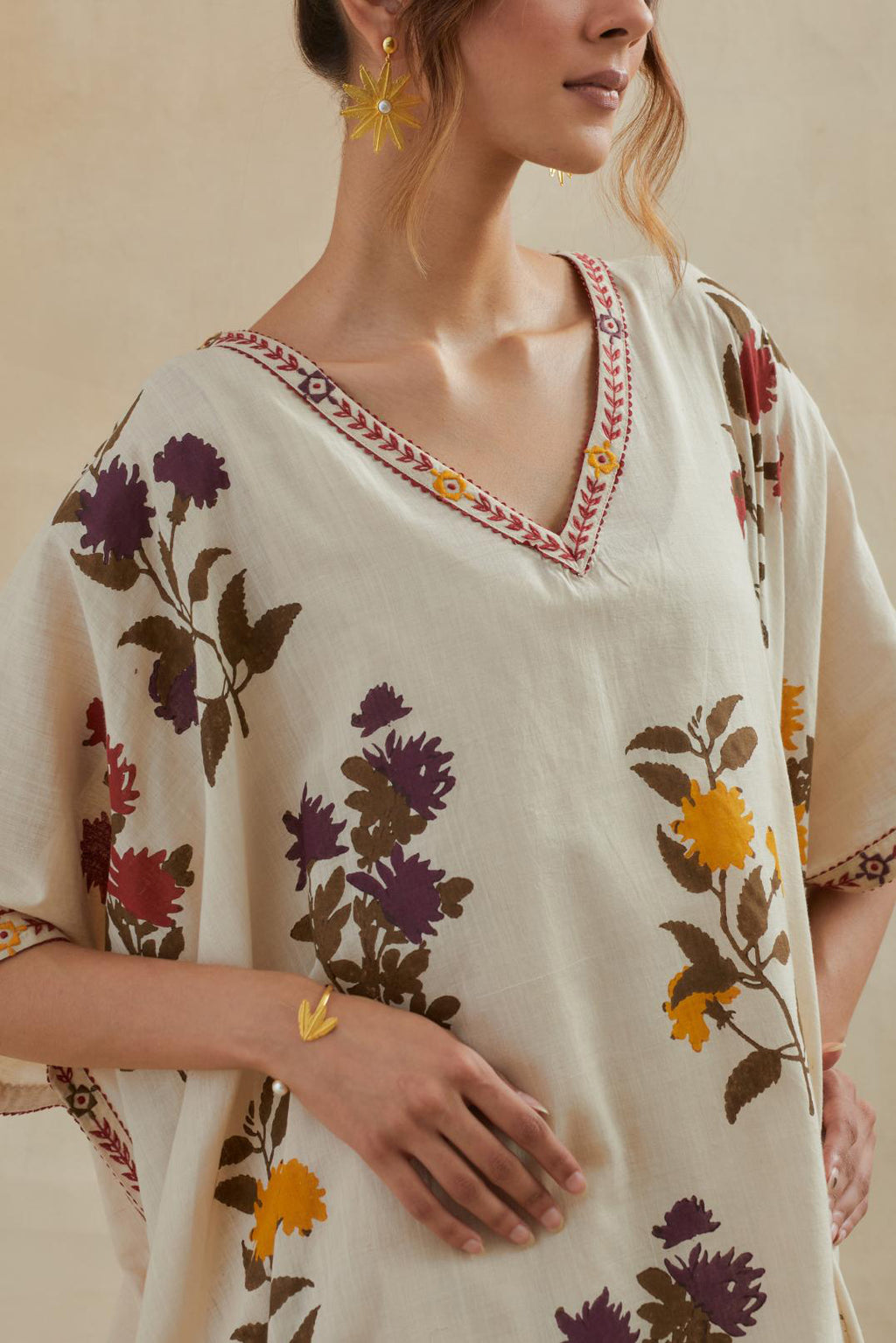 Beige cotton easy fit kaftan with all-over multi colored flower hand block print, highlighted with thread embroidery at sides, paired with beige cotton straight pants with all-over small booti hand block print.
