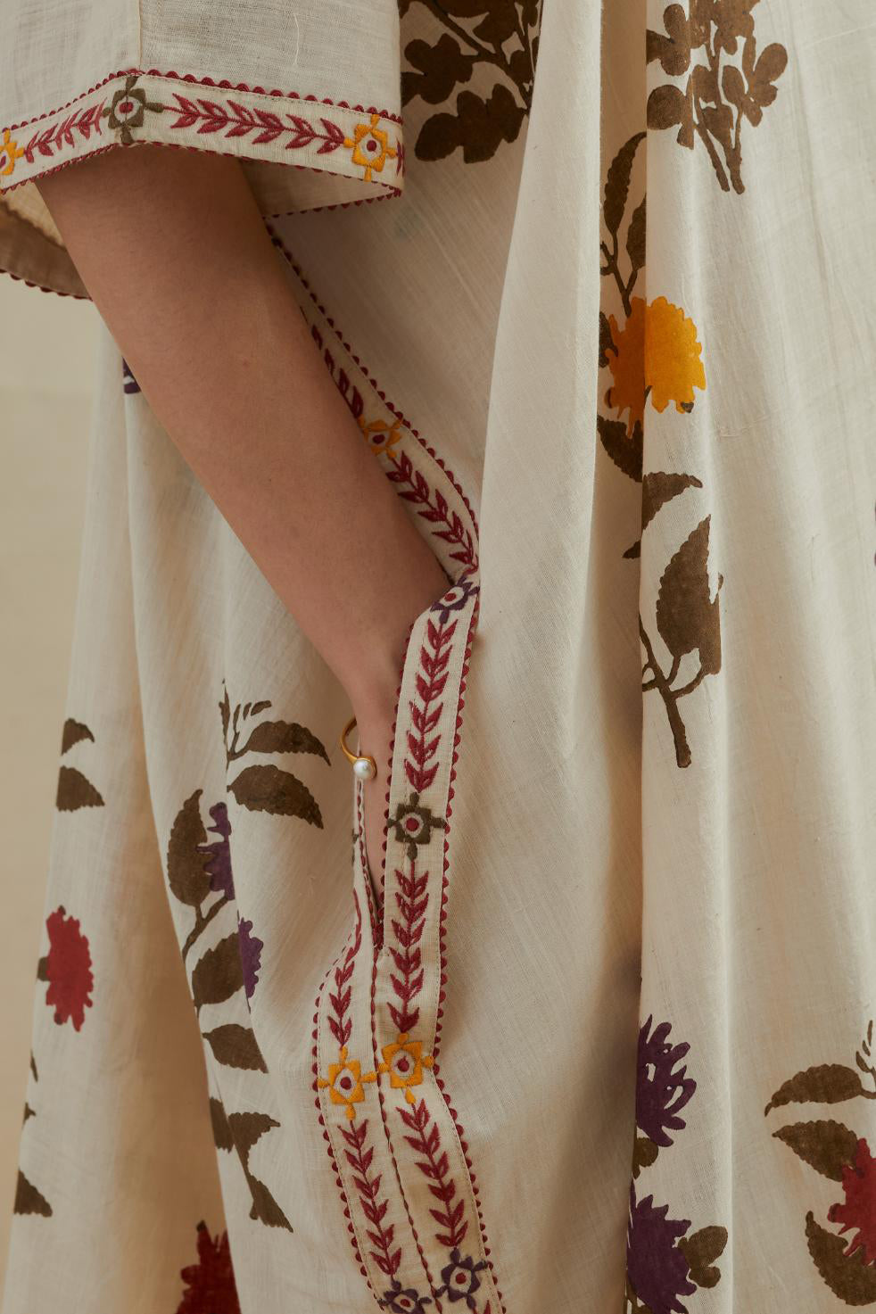 Beige cotton easy fit kaftan with all-over multi colored flower hand block print, highlighted with thread embroidery at sides, paired with beige cotton straight pants with all-over small booti hand block print.