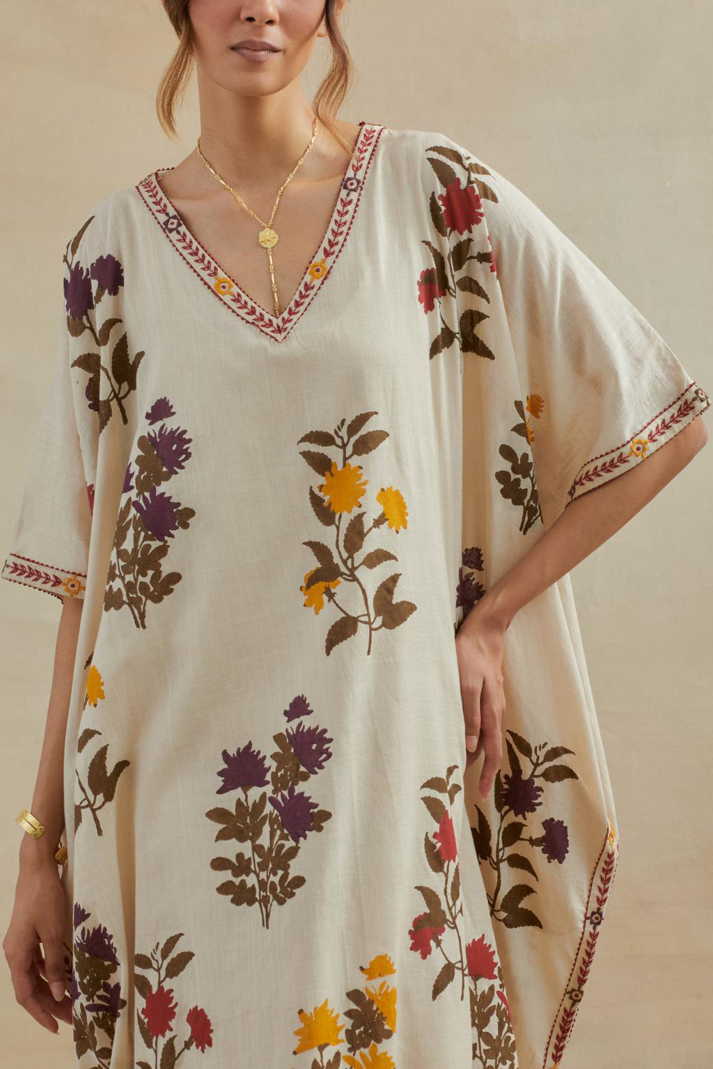 Beige cotton easy fit kaftan with all-over multi colored flower hand block print, highlighted with thread embroidery at sides, paired with beige cotton straight pants with all-over small booti hand block print.