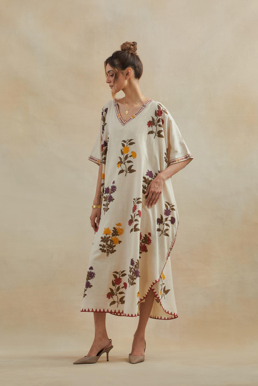 Beige cotton easy fit kaftan with all-over multi colored flower hand block print, highlighted with thread embroidery at sides, paired with beige cotton straight pants with all-over small booti hand block print.