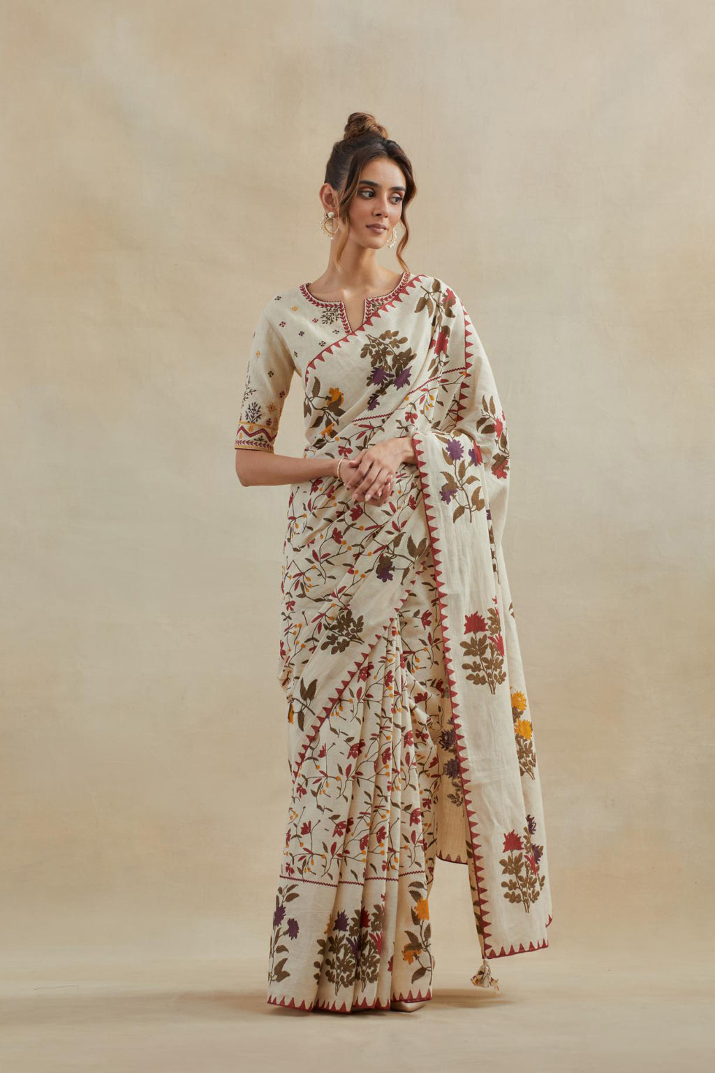 Beige cotton saree with all-over multi colored floral jaal hand block print and boota at saree hem and pallu, paired with beige cotton blouse with all-over multi colored thread embroidery.