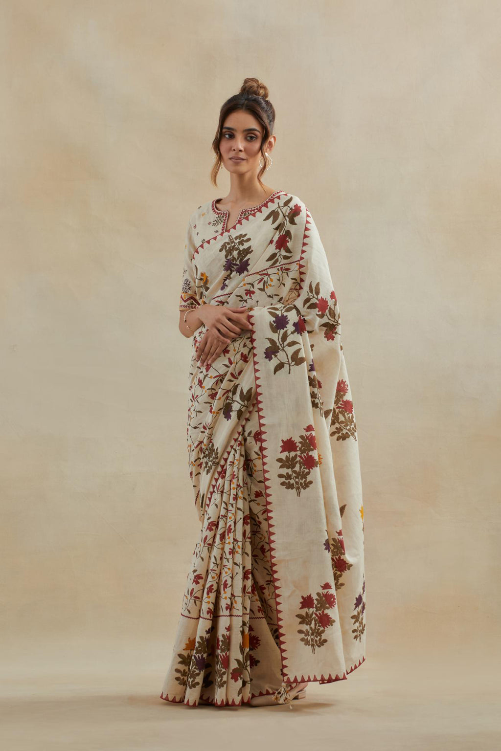 Beige cotton saree with all-over multi colored floral jaal hand block print and boota at saree hem and pallu, paired with beige cotton blouse with all-over multi colored thread embroidery.