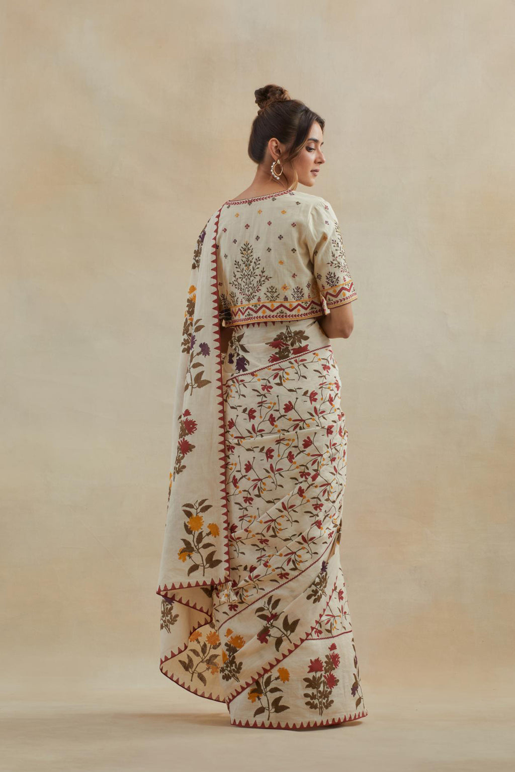 Beige cotton blouse with all-over multi colored thread embroidery.