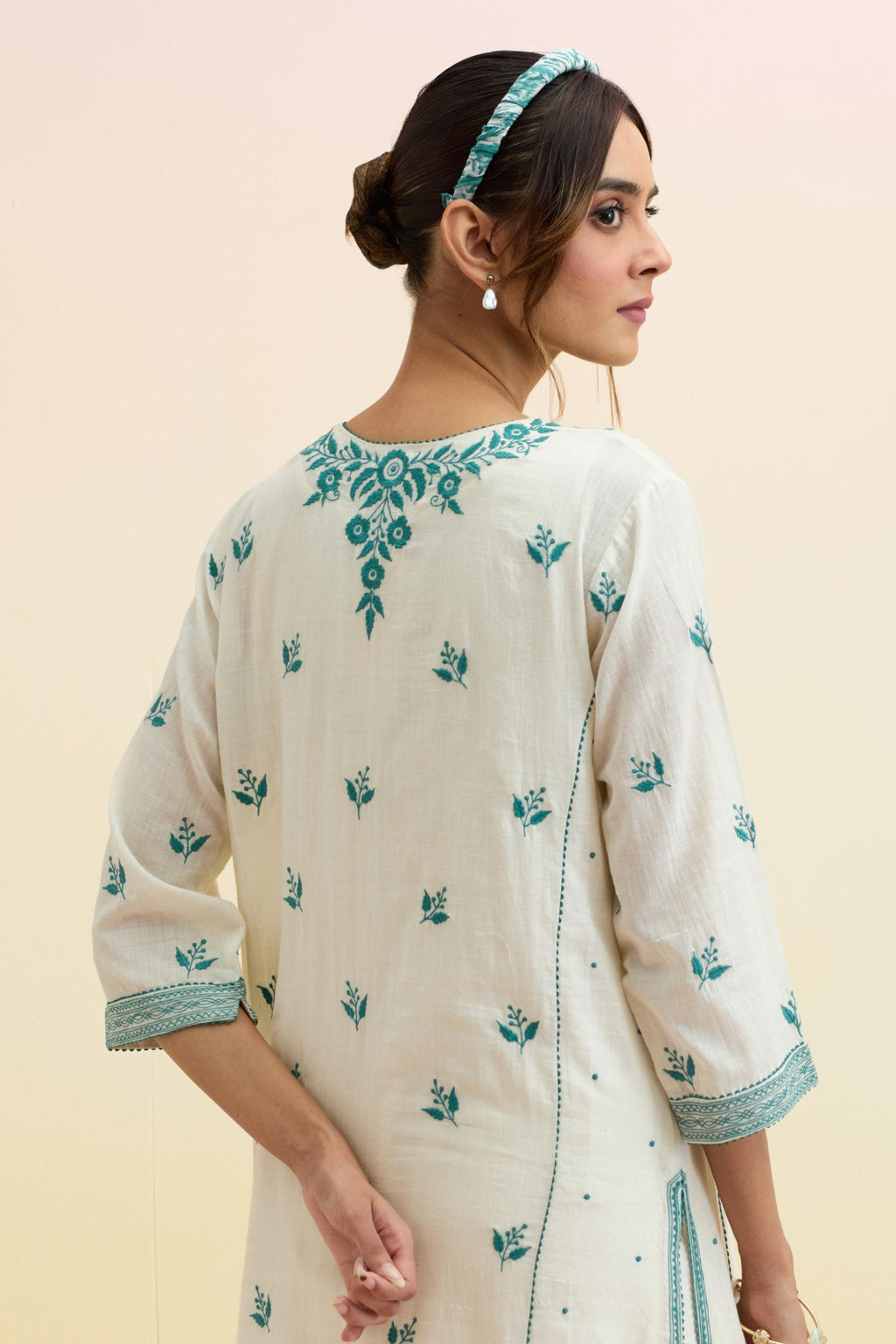 Off white cotton kalidar straight kurta set, highlighted with tropical teal thread embroidery.