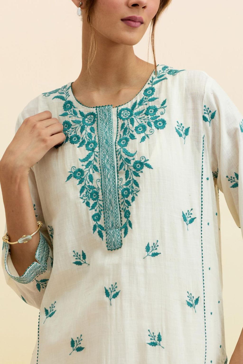 Off white cotton kalidar straight kurta set, highlighted with tropical teal thread embroidery.