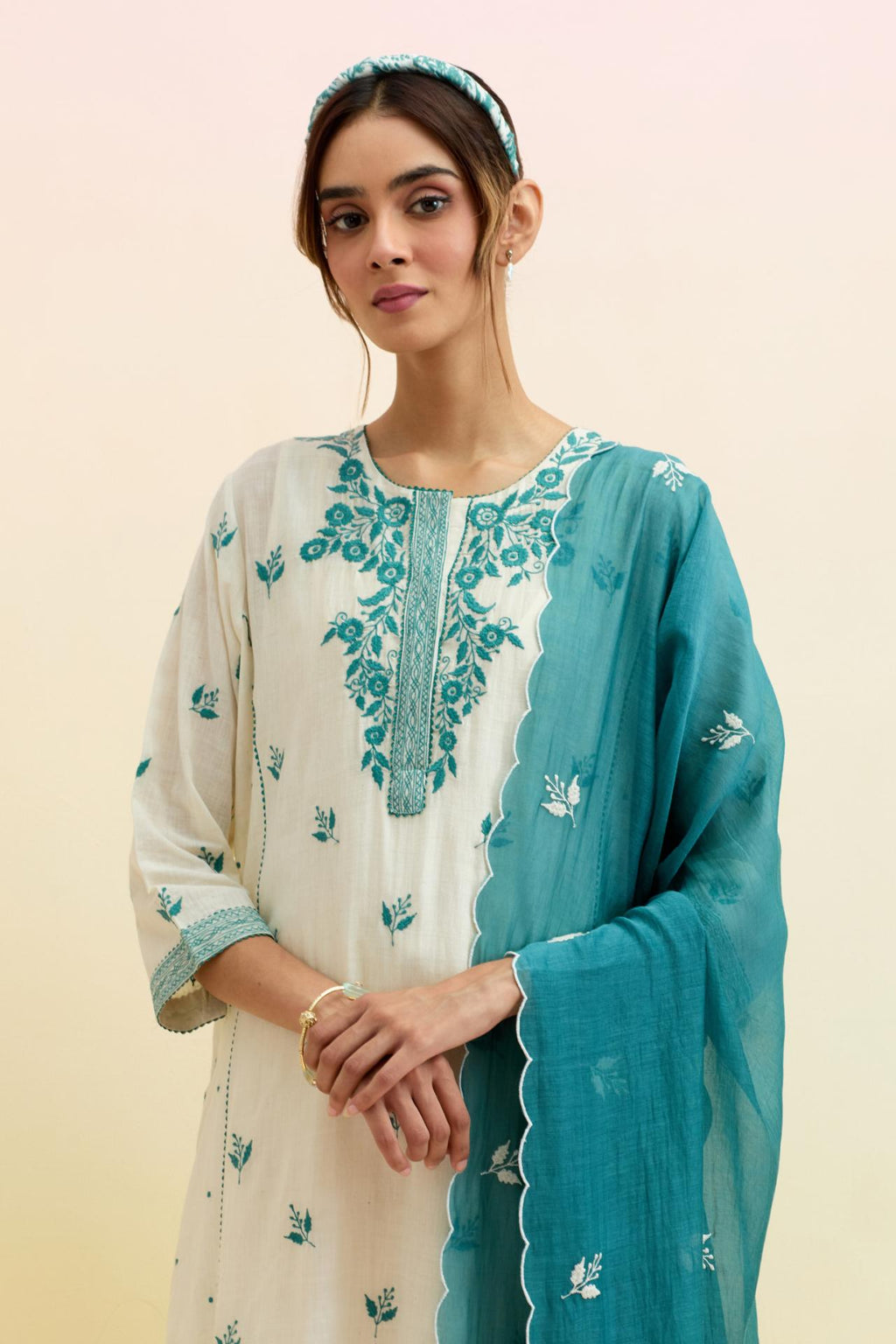 Off white cotton kalidar straight kurta set, highlighted with tropical teal thread embroidery.