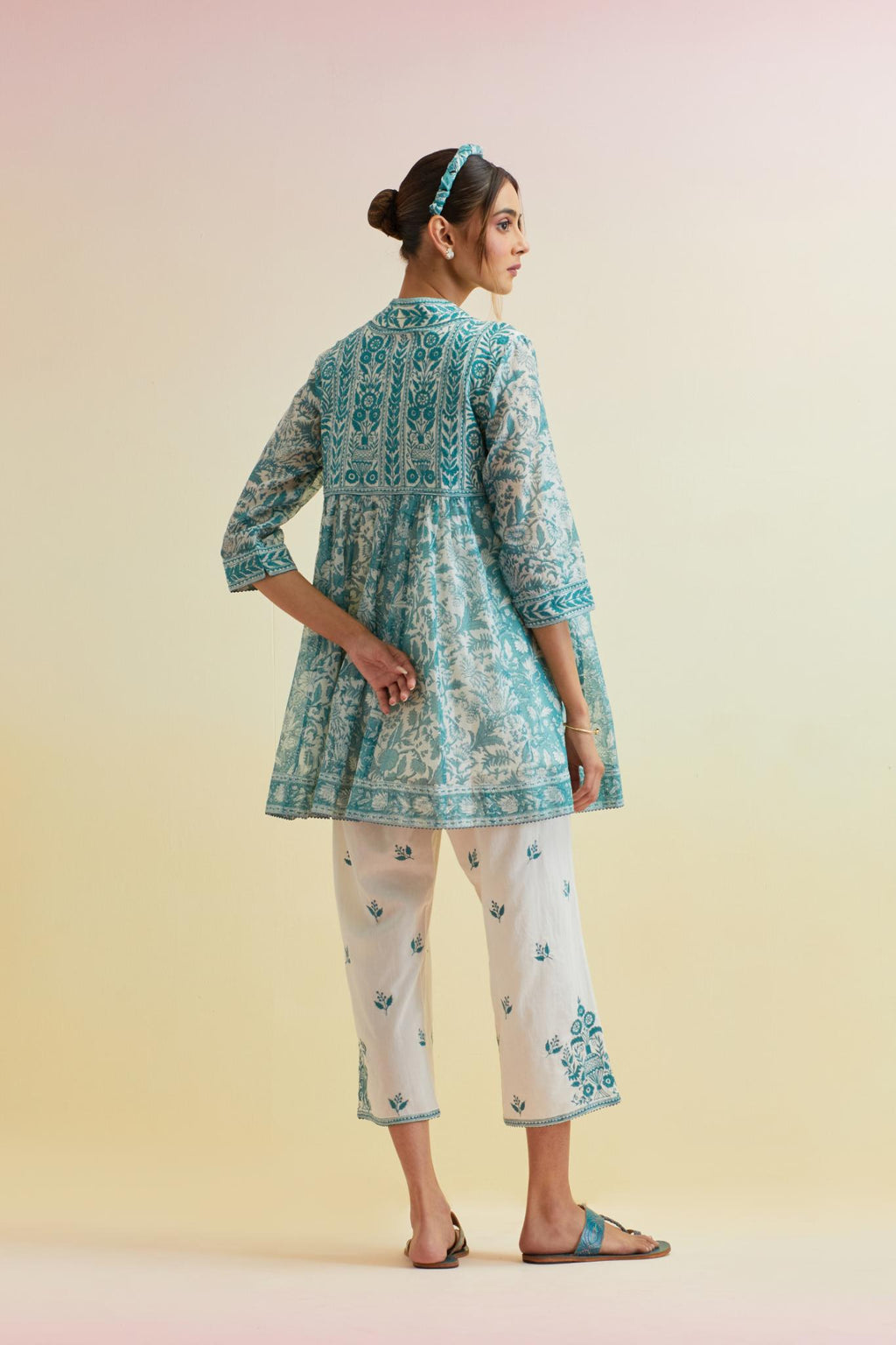 Tropical teal hand block printed short angrakha kurta with embroidered neckline, paired with off white cotton straight ankle length pants with embroidered boota at sides and all-over small floral booti.