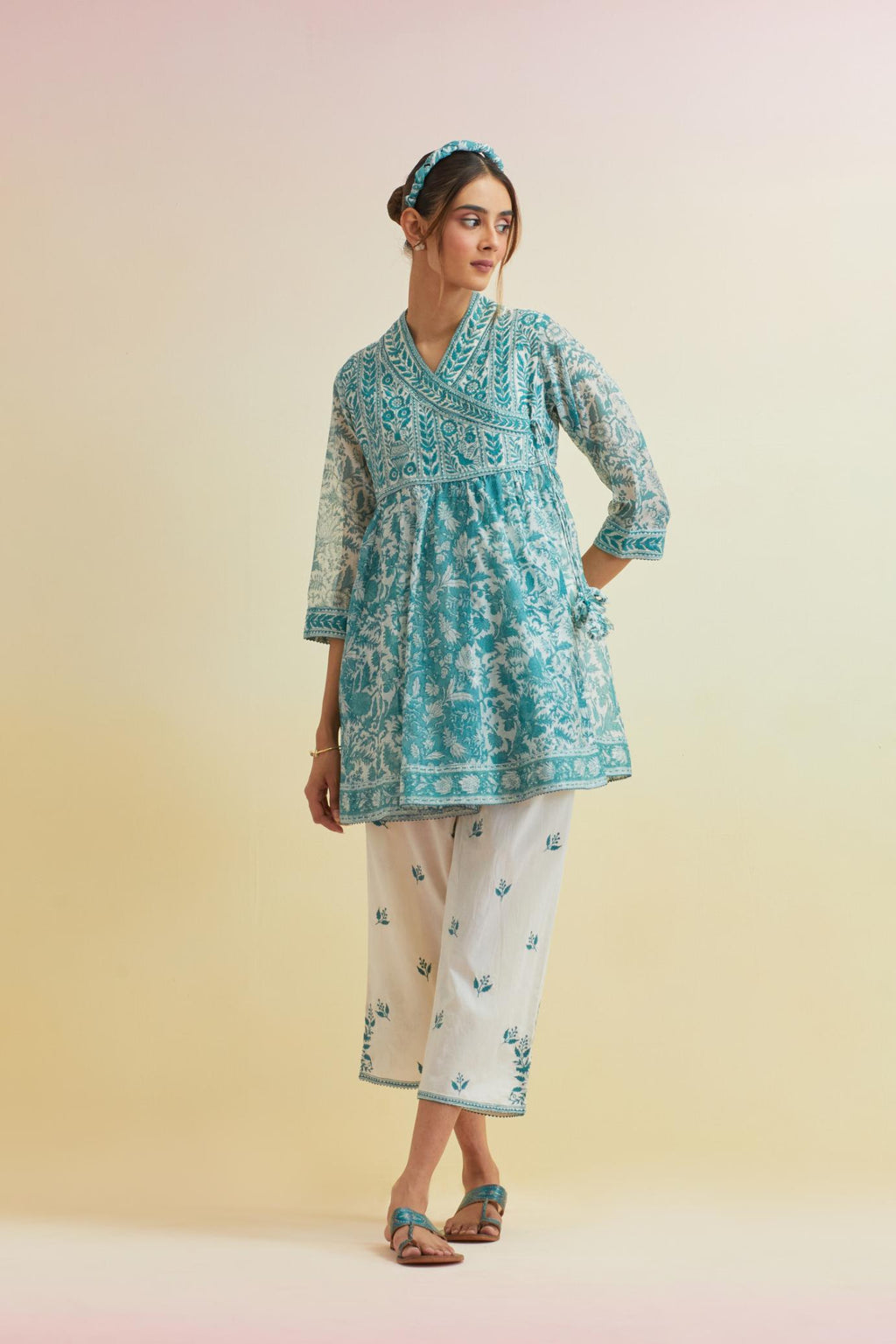 Tropical teal hand block printed short angrakha kurta with embroidered neckline, paired with off white cotton straight ankle length pants with embroidered boota at sides and all-over small floral booti.