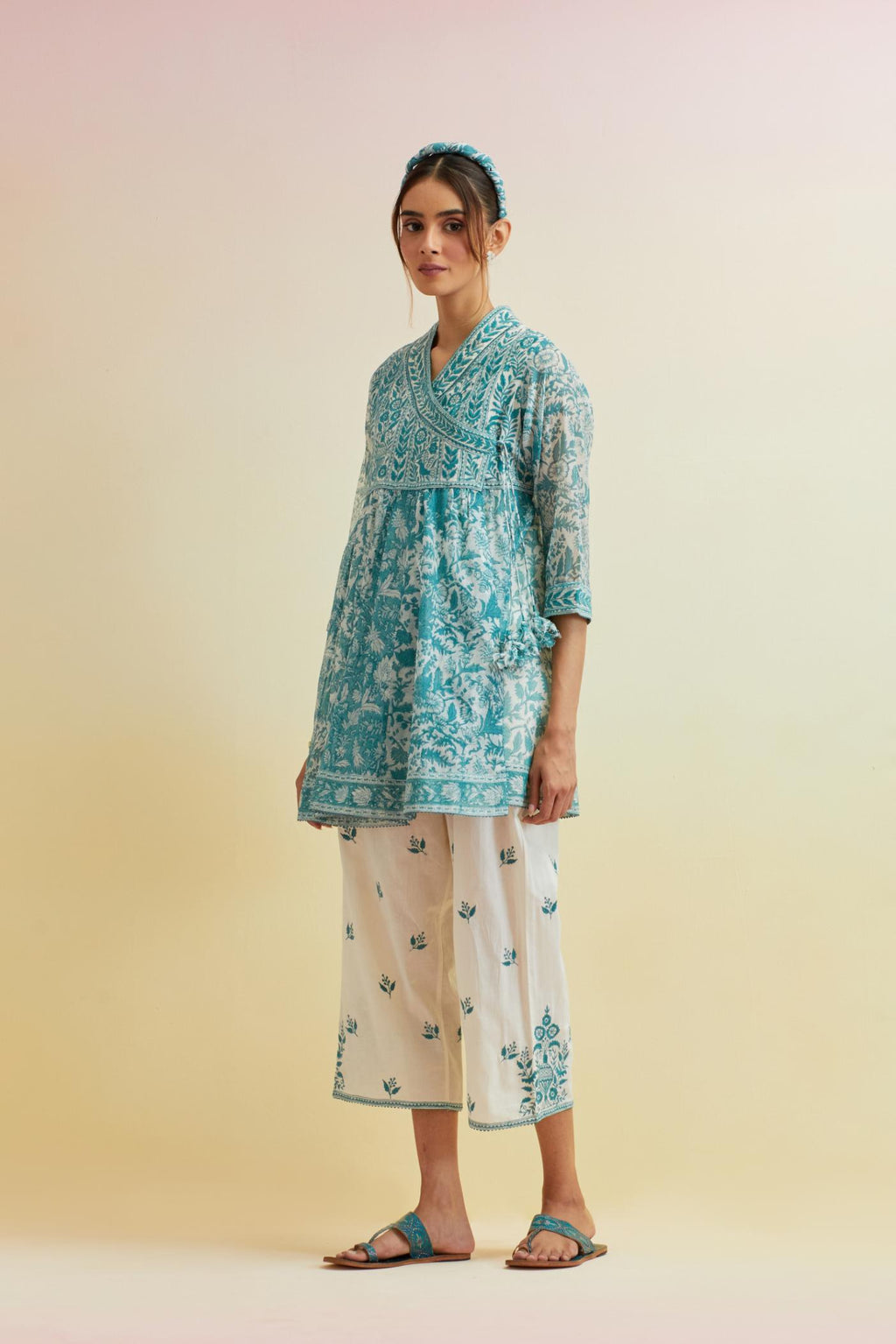 Tropical teal hand block printed short angrakha kurta with embroidered neckline, paired with off white cotton straight ankle length pants with embroidered boota at sides and all-over small floral booti.