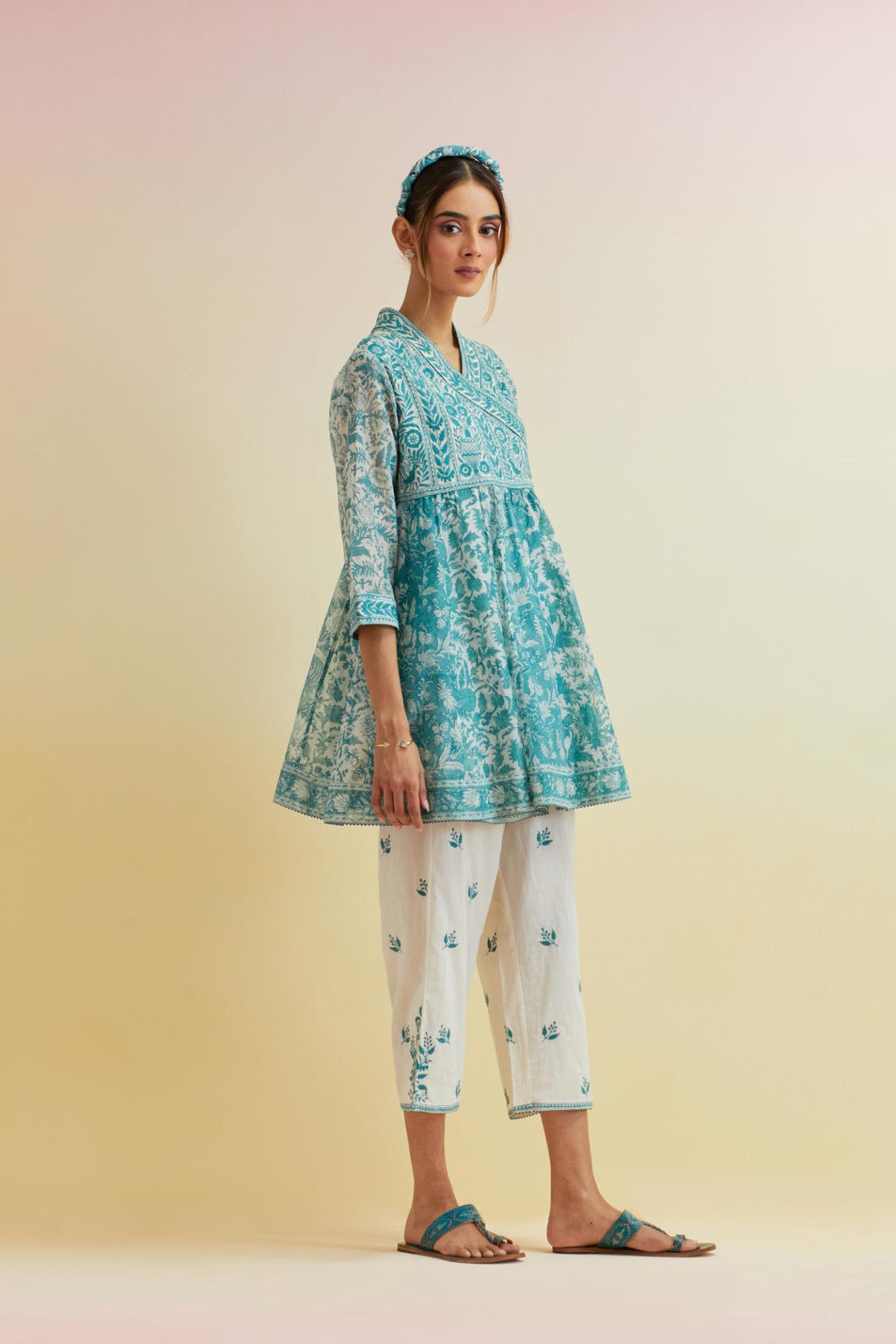 Tropical teal hand block printed short angrakha kurta with embroidered neckline, paired with off white cotton straight ankle length pants with embroidered boota at sides and all-over small floral booti.