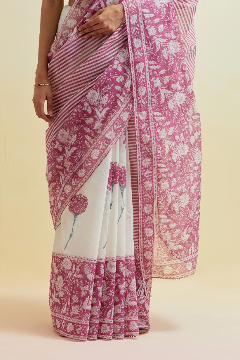 Orchid pink hand block cotton chanderi saree, highlighted with all-over carnation flower print, paired with off-white cotton blouse with all-over tropical teal thread embroidery.