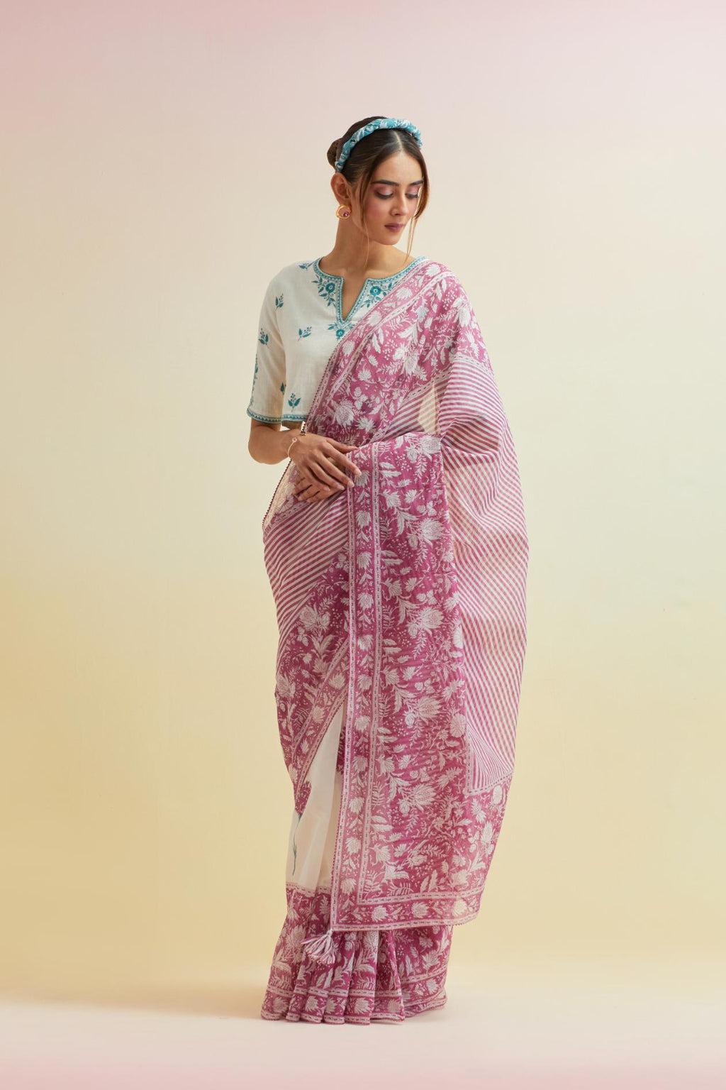 Orchid pink hand block cotton chanderi saree, highlighted with all-over carnation flower print, paired with off-white cotton blouse with all-over tropical teal thread embroidery.